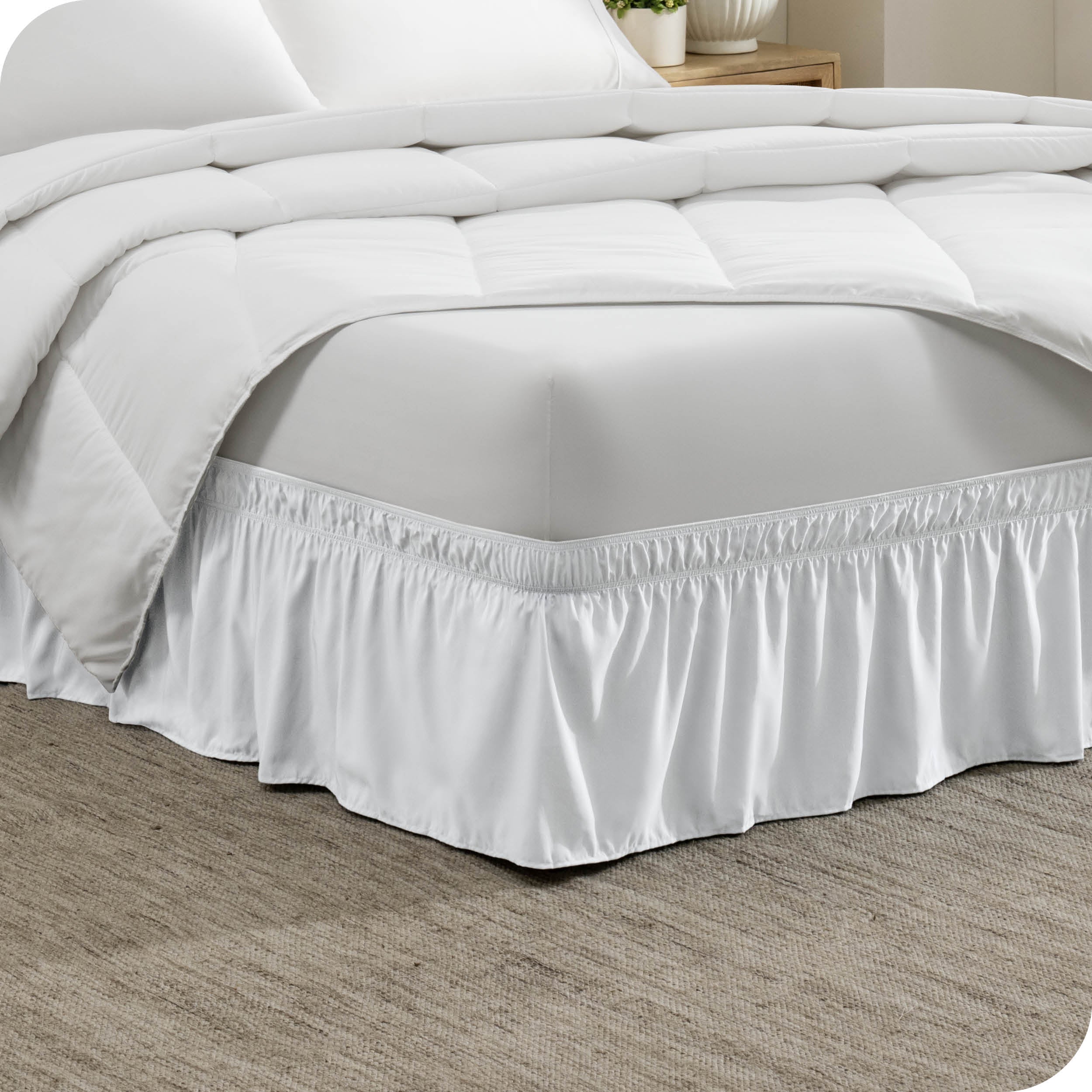 The corner of a bed with a polyester bed skirt on it
