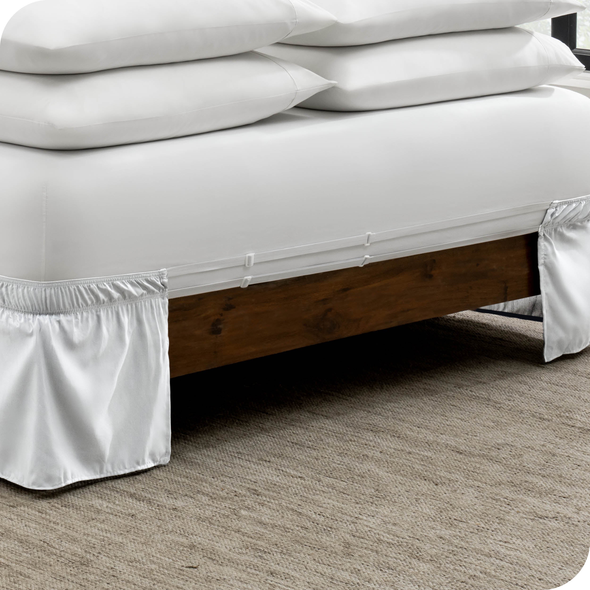 The adjustable elastic belt of a bed skirt wrapped around the mattress