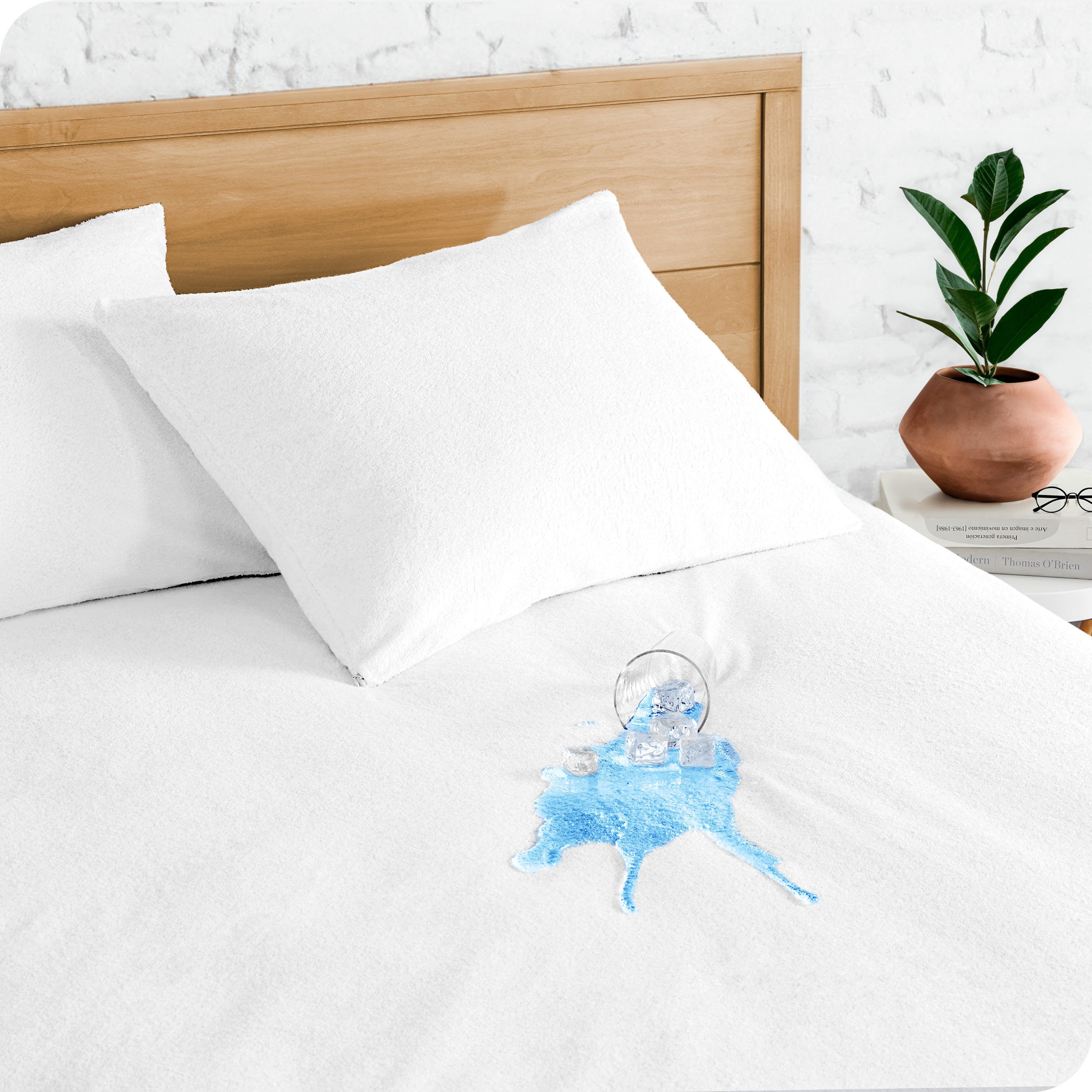 A glass of water spilled on a mattress protector