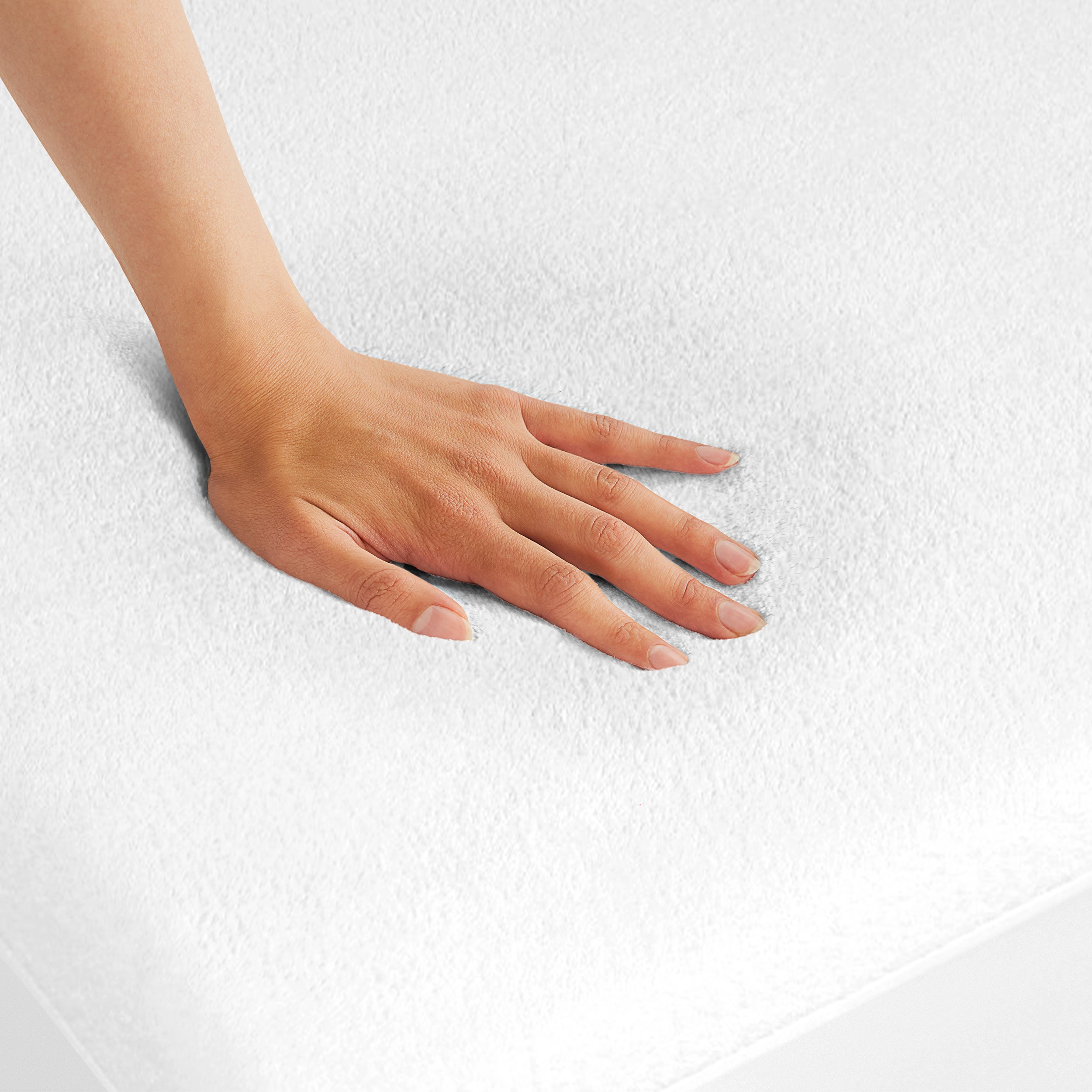 A hand is feeling the texture of the mattress protector.