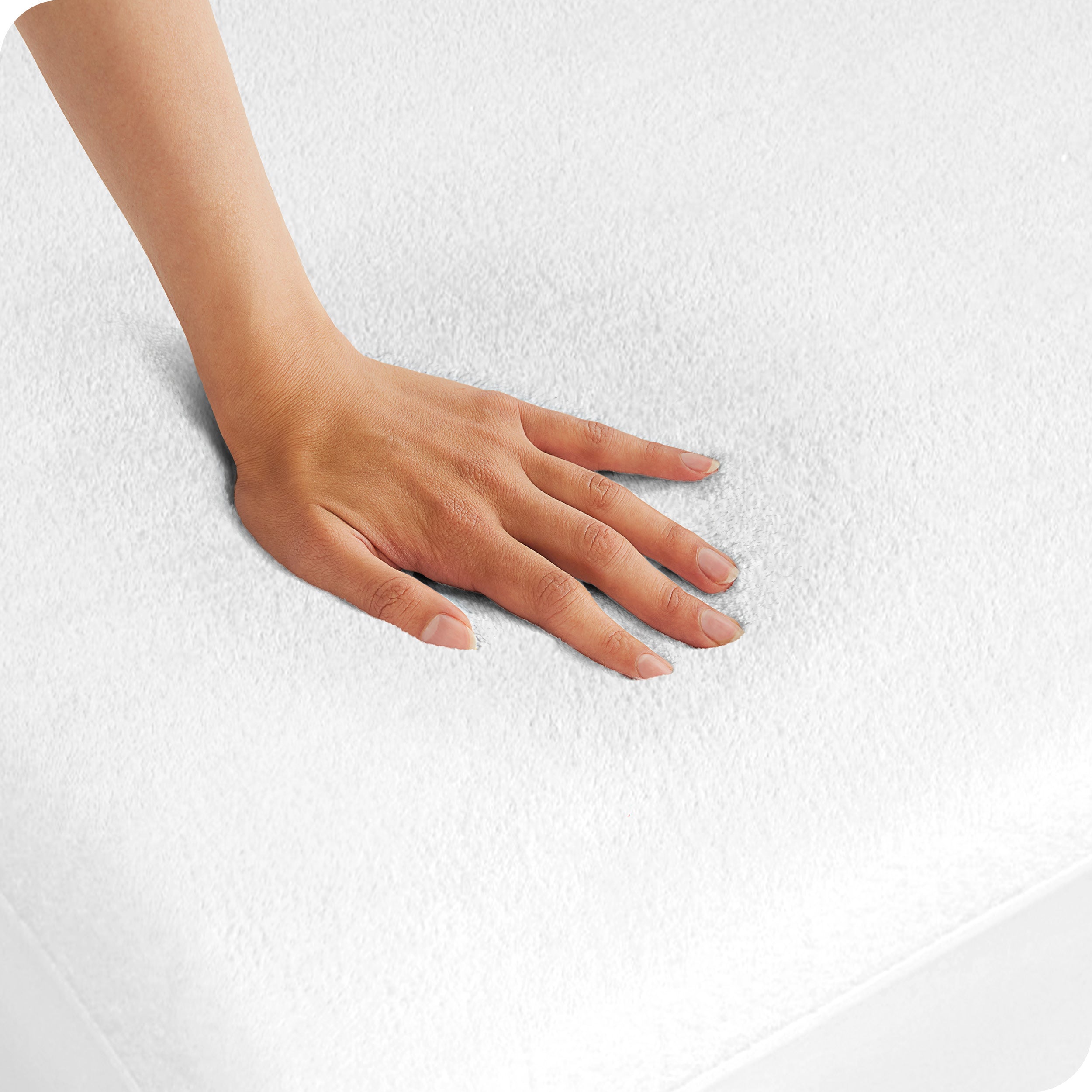 A woman is pressing her hand down on a mattress with a protector on it