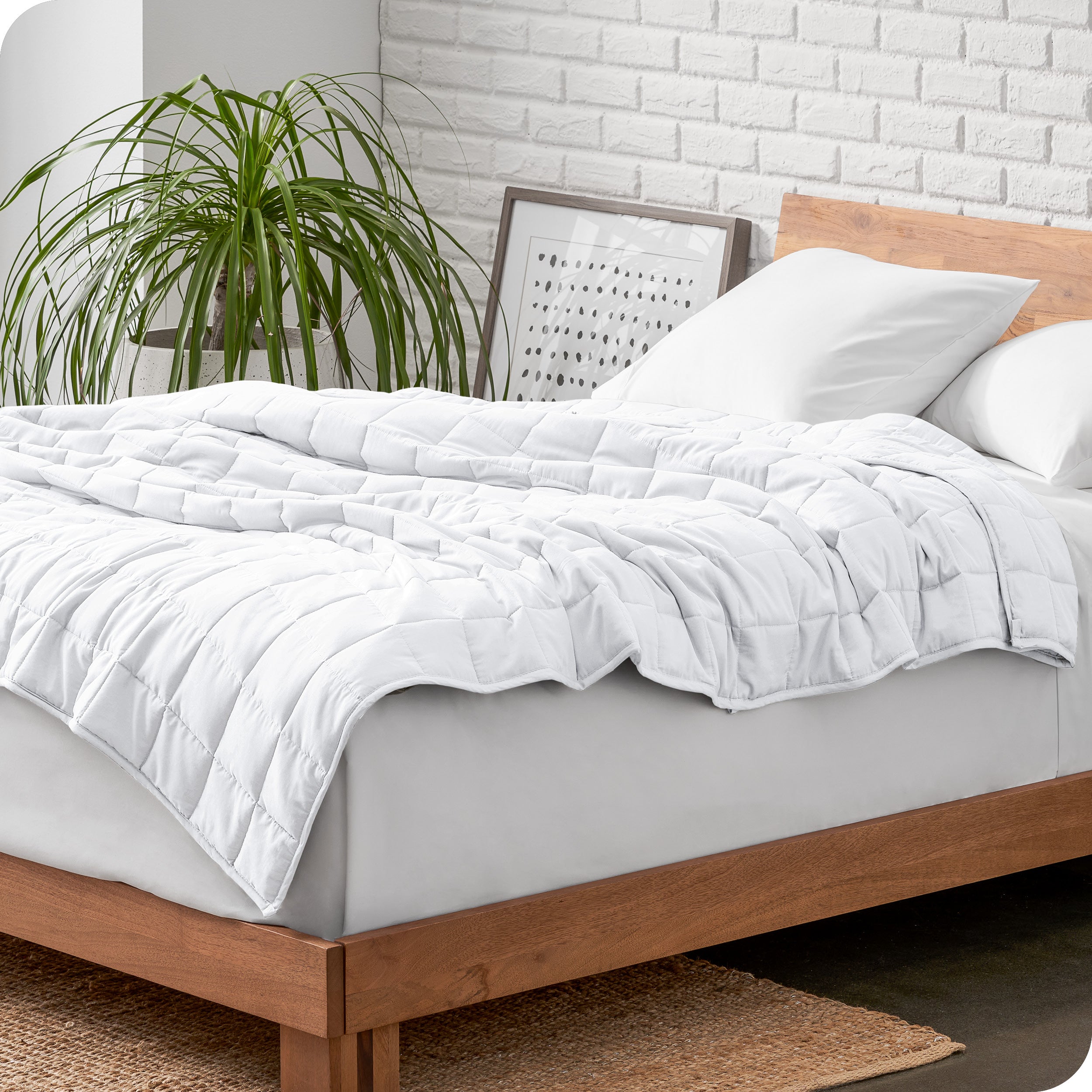 A cotton weighted blanket is loosely draped over a bed