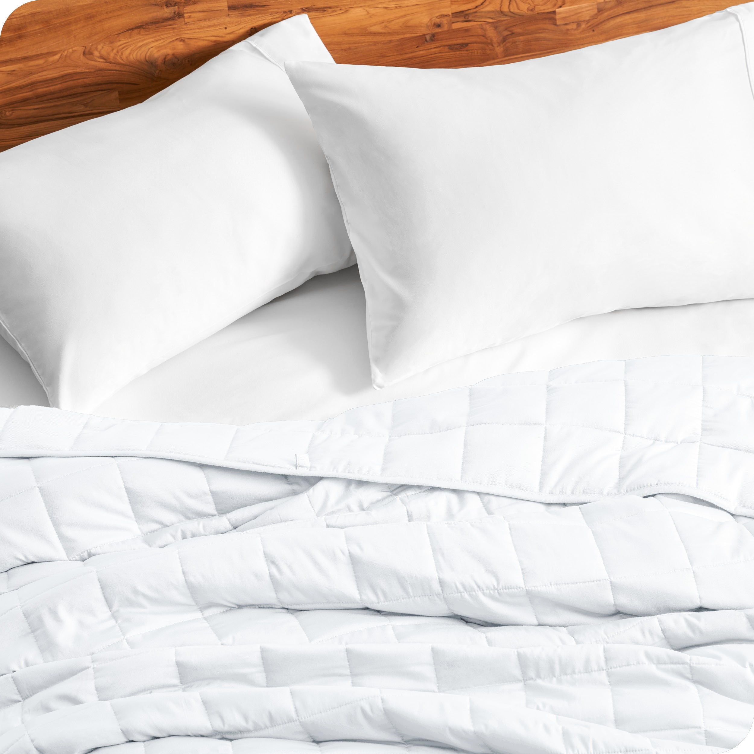 Close up of a weighted blanket on a bed with  2 pillows
