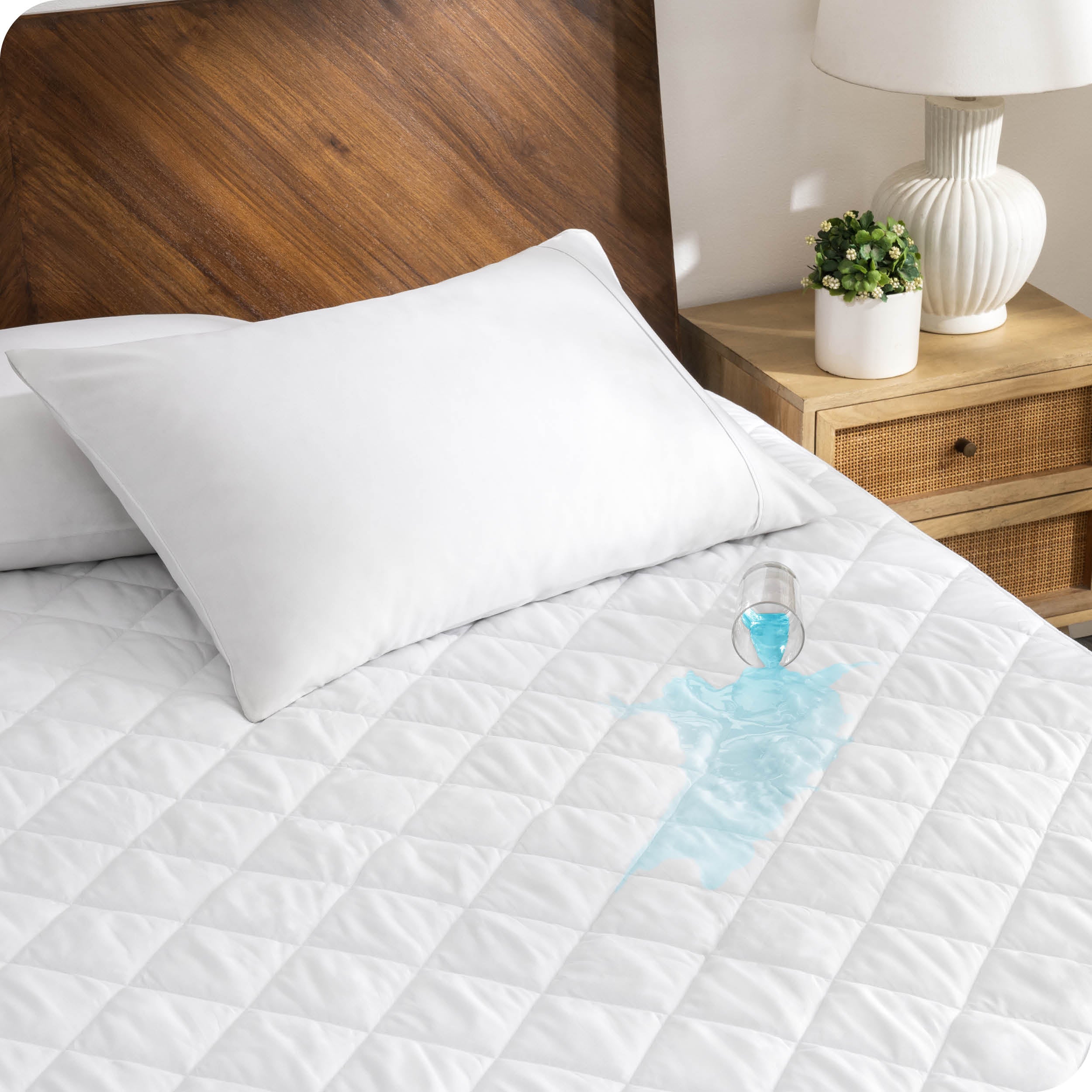 A glass of water is spilled on a waterproof mattress pad