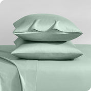 Two sateen pillowcases stacked on a bed