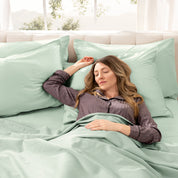 A woman sleeping on a bed made with organic cotton sateen sheets and pillowcases