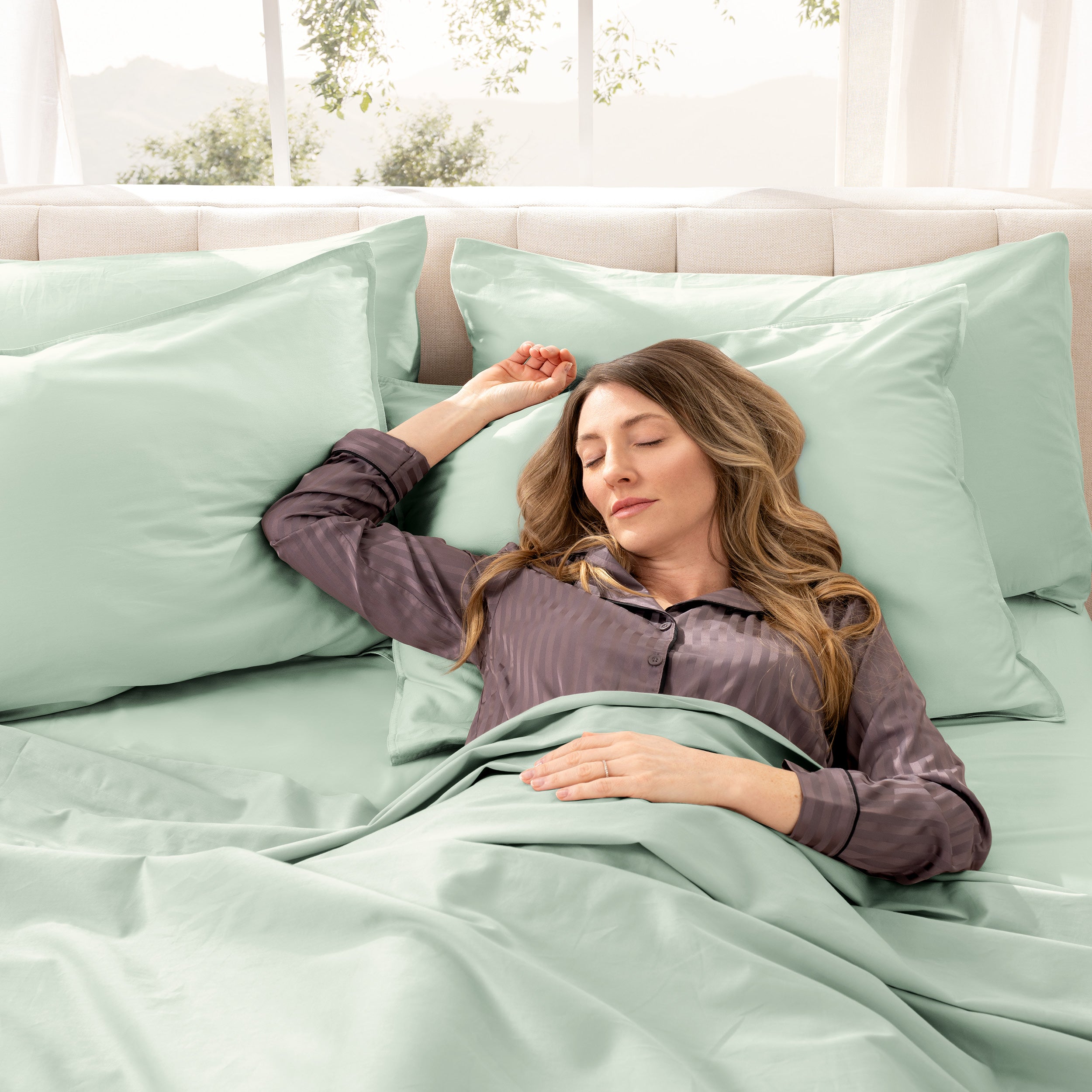 A woman sleeping on a bed made with organic cotton sateen sheets and pillowcases