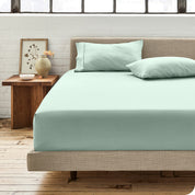 Percale fitted sheet on a mattress with matching pillowcases on pillows