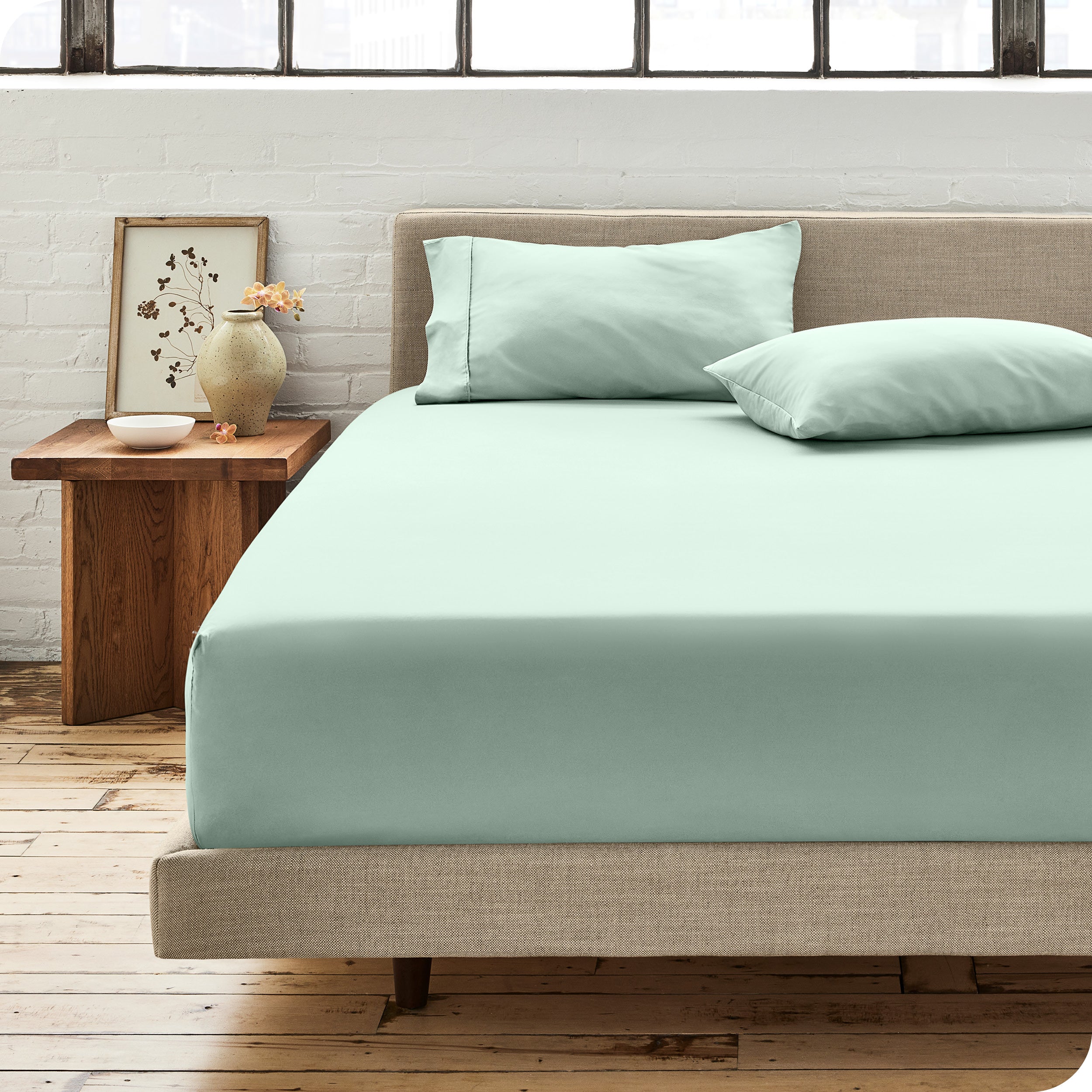 Percale fitted sheet on a mattress with matching pillowcases on pillows