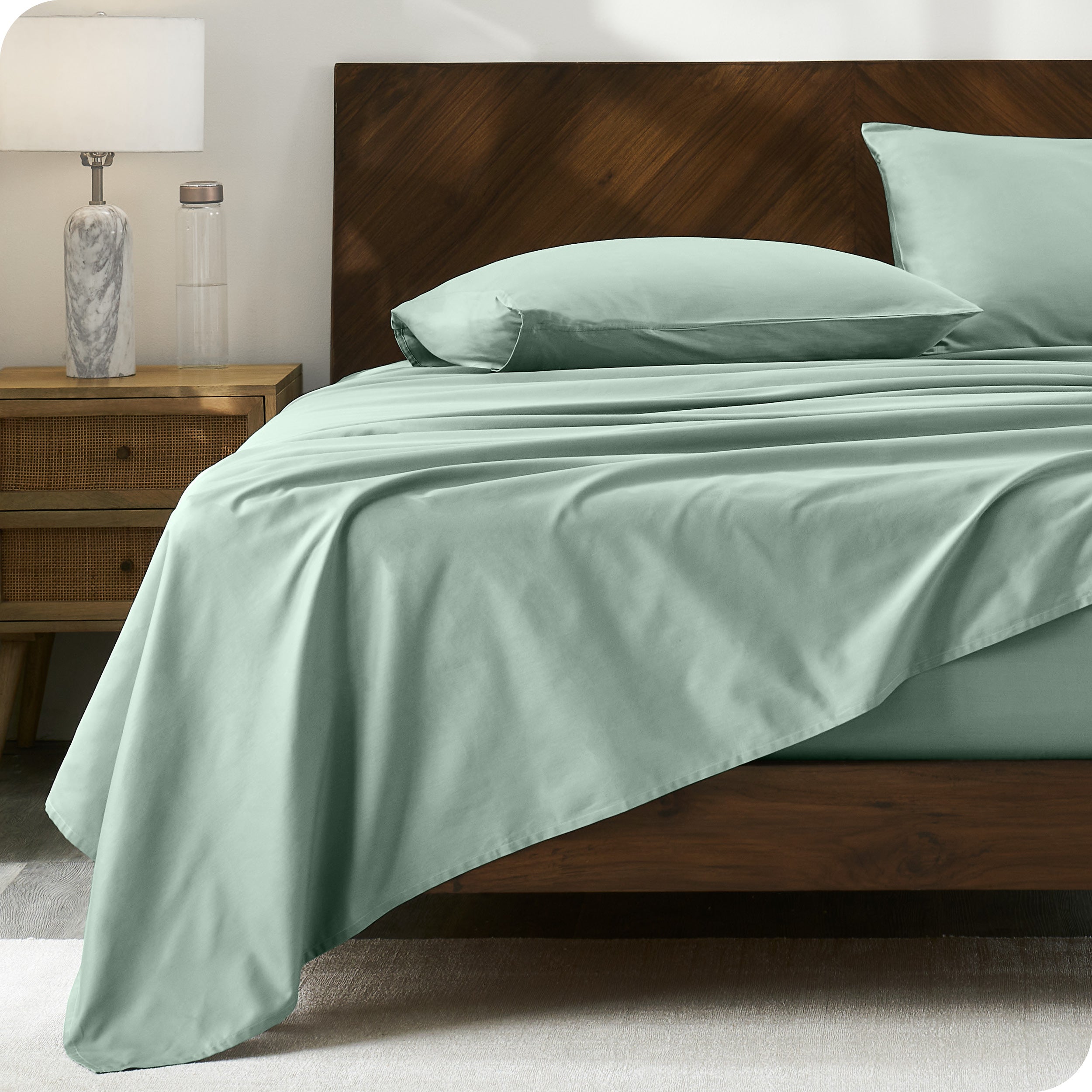 Percale sheet set on a bed with a wooden headboard