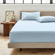 Percale fitted sheet on a mattress with matching pillowcases on pillows