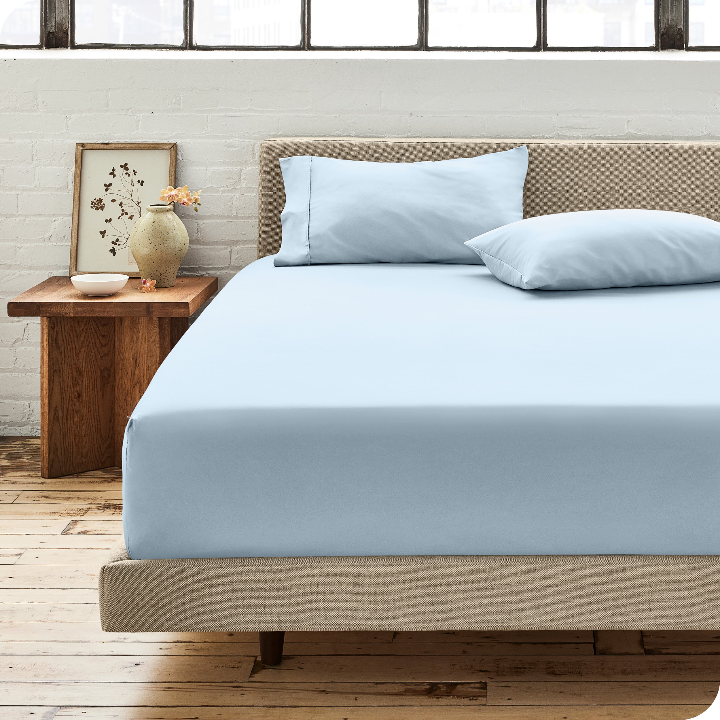 Percale fitted sheet on a mattress with matching pillowcases on pillows
