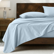 Percale sheet set on a bed with a wooden headboard