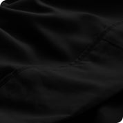 Close up of a white microfiber sheet showing the stitching and texture