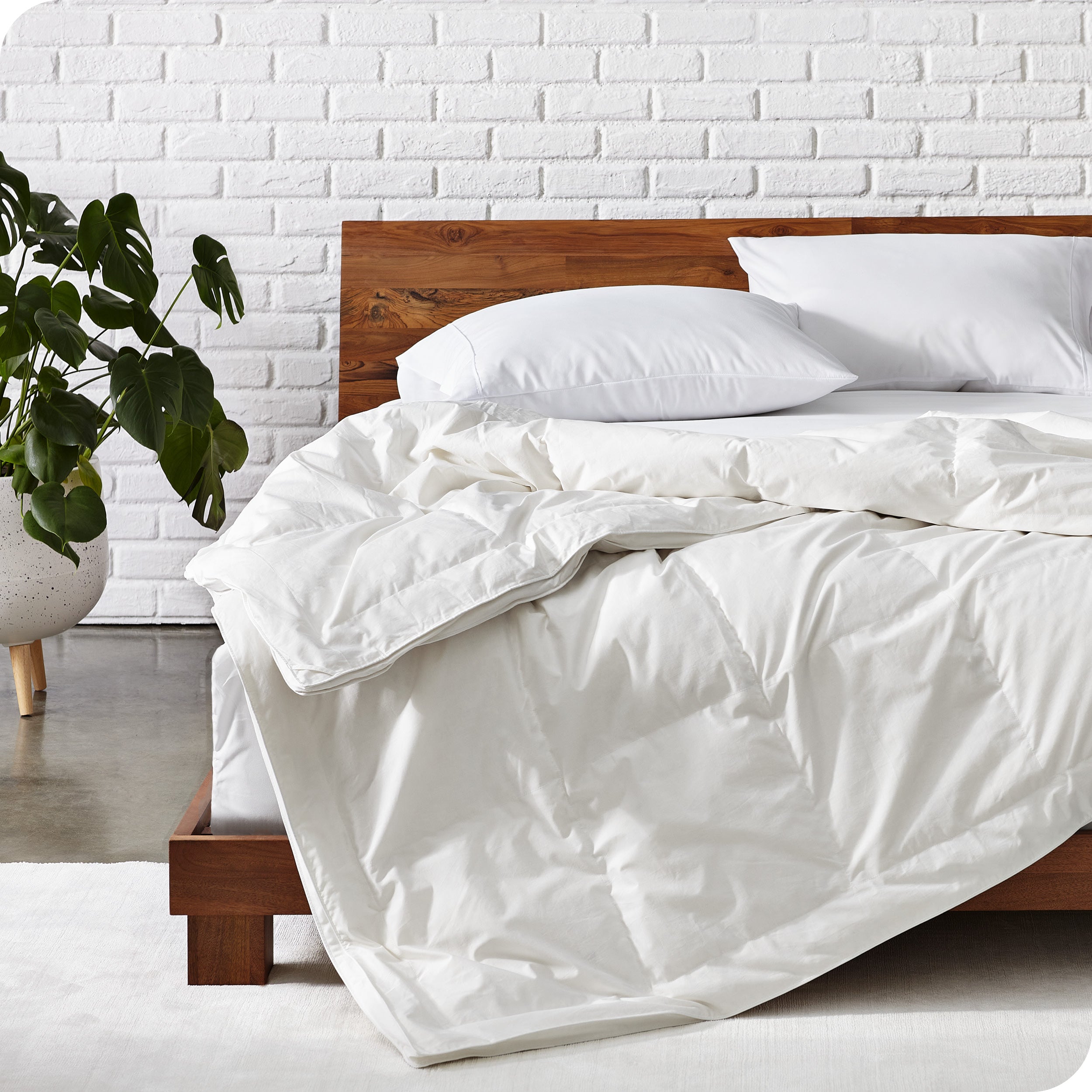 A modern bed with a  white down comforter