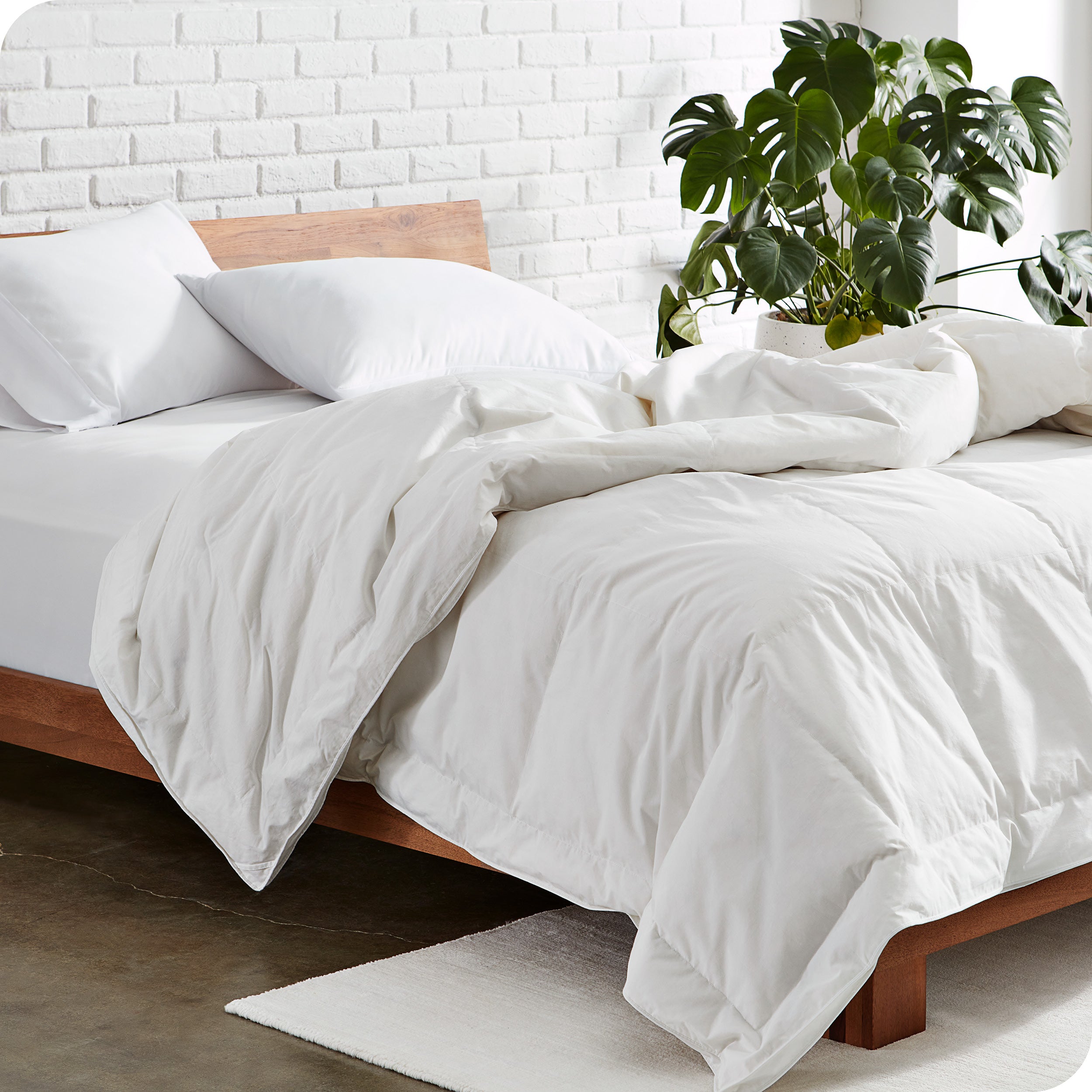 A modern bed with a white down comforter