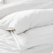 A corner of the down comforter showing the texture and lining.