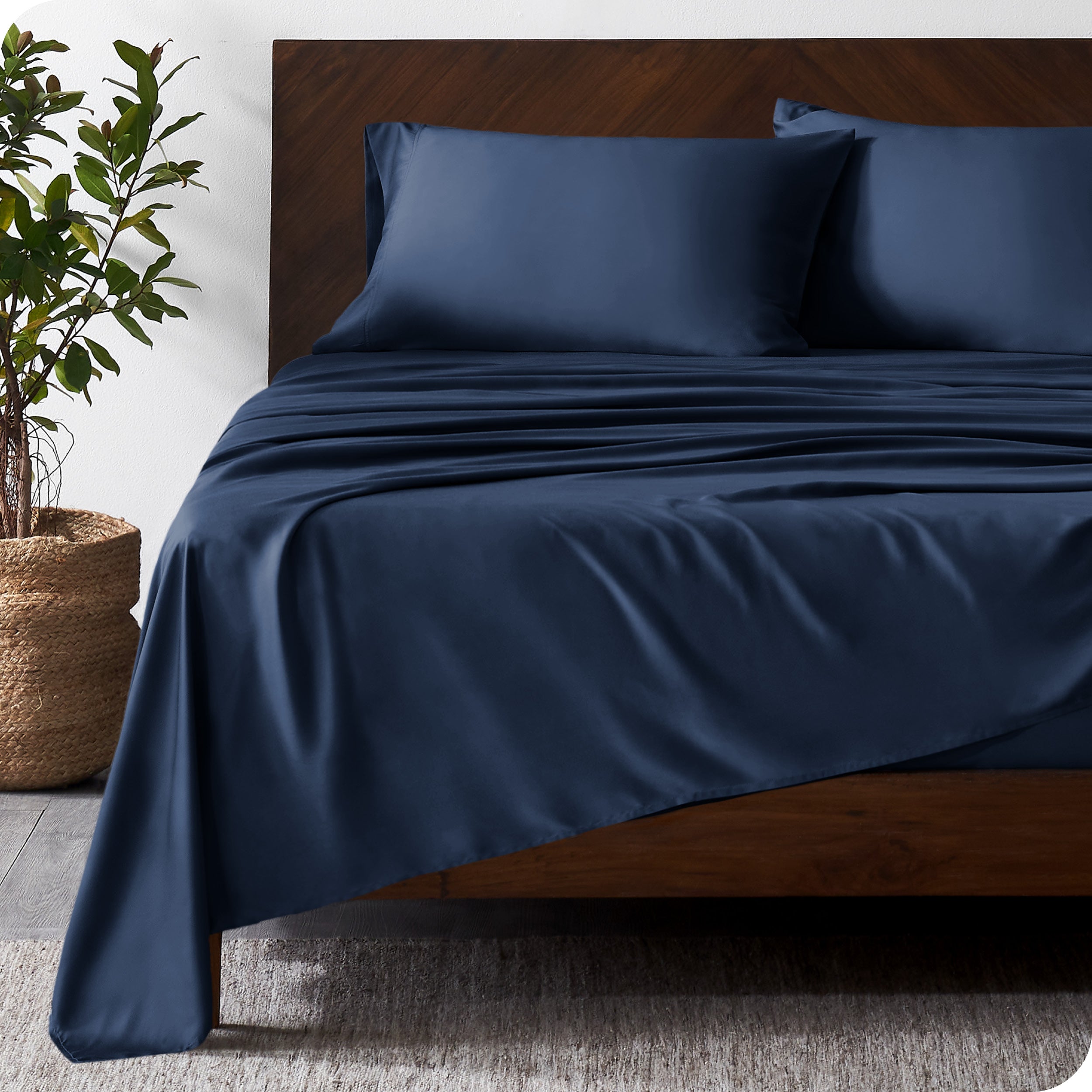 Wooden bed frame with bamboo sheets on the bed