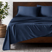 Wooden bed frame with bamboo sheets on the bed