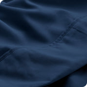 Close up of a white microfiber sheet showing the stitching and texture