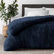 A dark blue shaggy duvet cover on a bed
