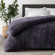 A purple shaggy duvet cover on a bed
