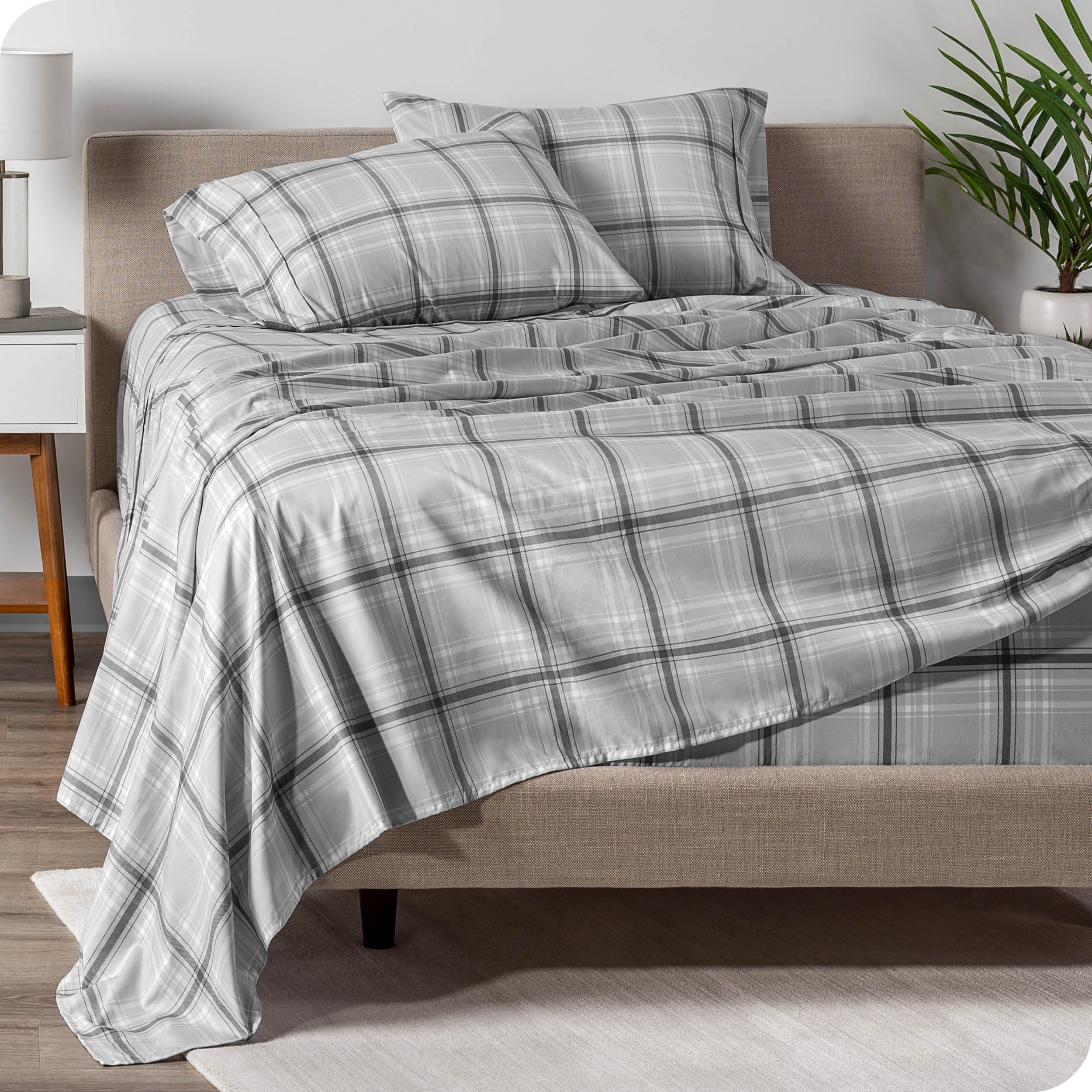 A modern bed with a printed microfiber sheet draped across the bed.