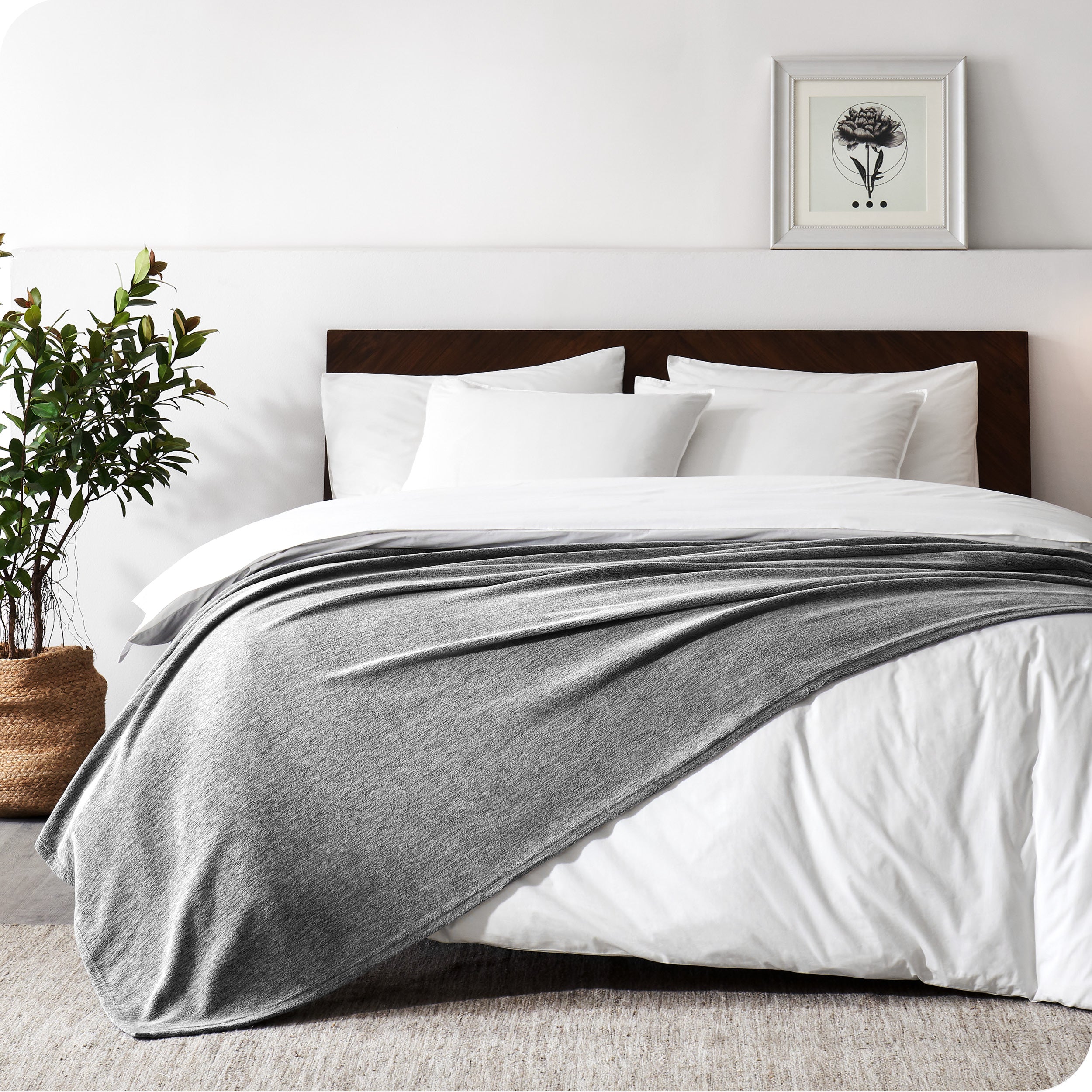 A sideview of a modern bed with a wooden bedframe and our polar fleece blanket on top of the bed.