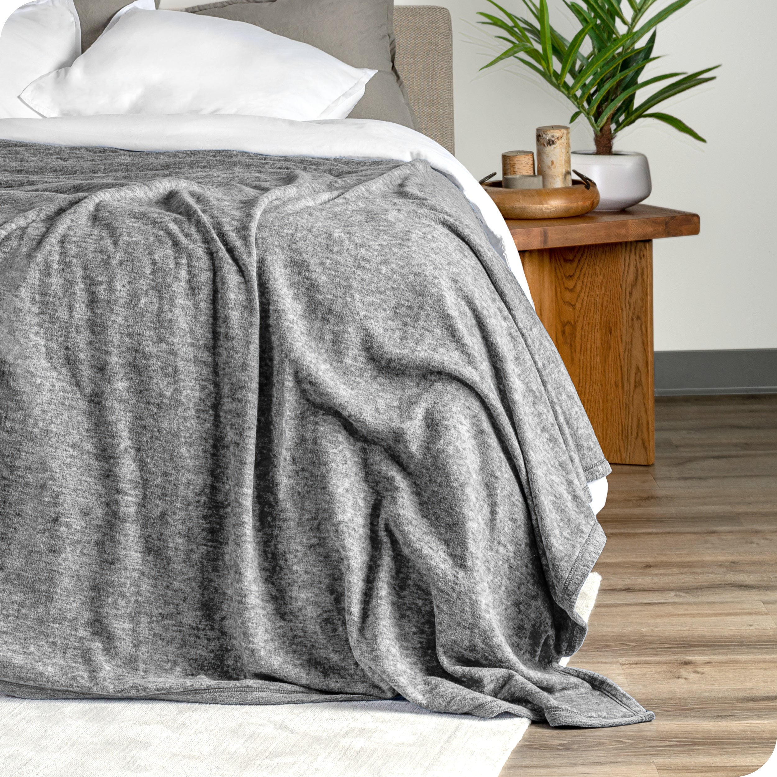 A close view of the end of the bed showing the polar fleece blanket draped on top showing the texture.