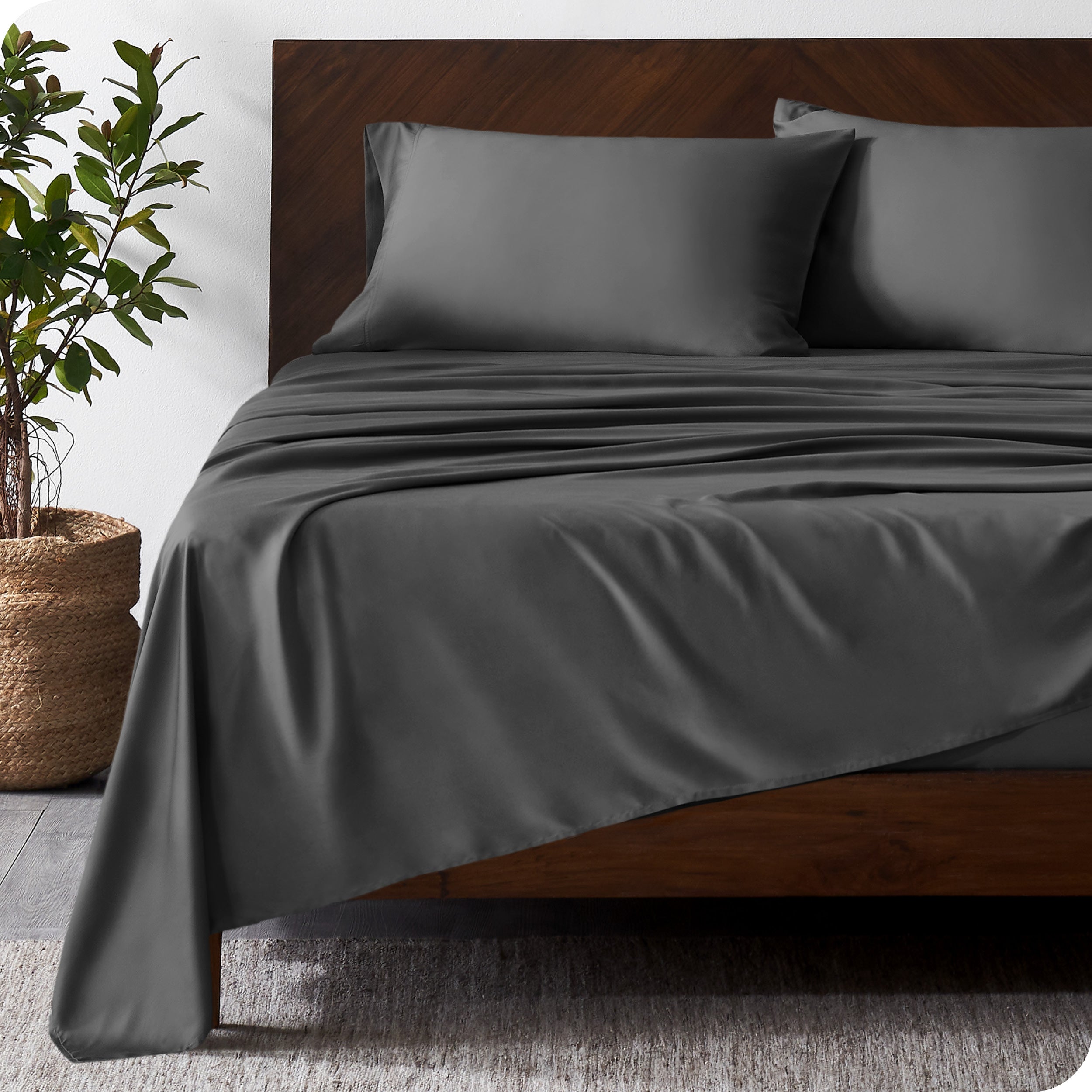 Wooden bed frame with bamboo sheets on the bed