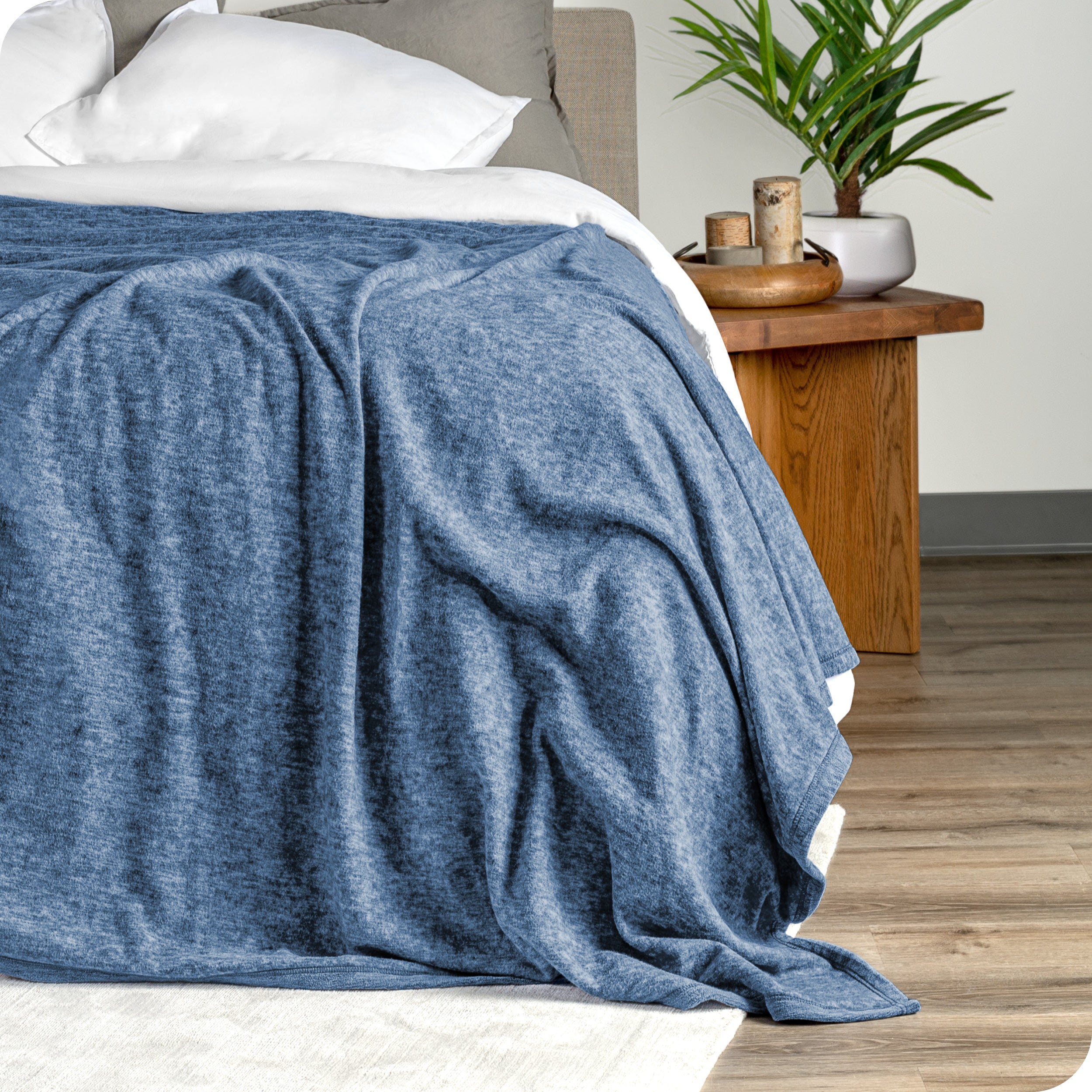 A close view of the end of the bed showing the polar fleece blanket draped on top showing the texture.