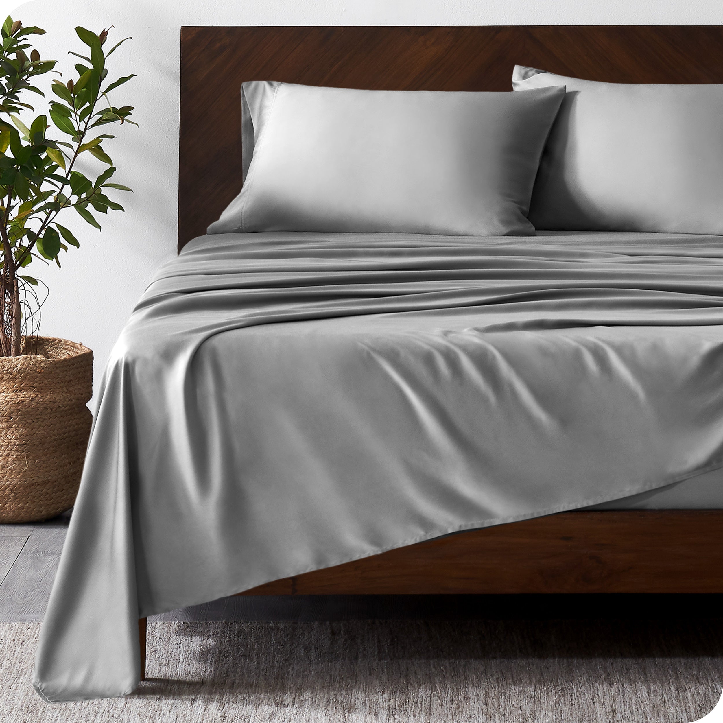 Wooden bed frame with bamboo sheets on the bed