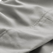 Close up of a white microfiber sheet showing the stitching and texture