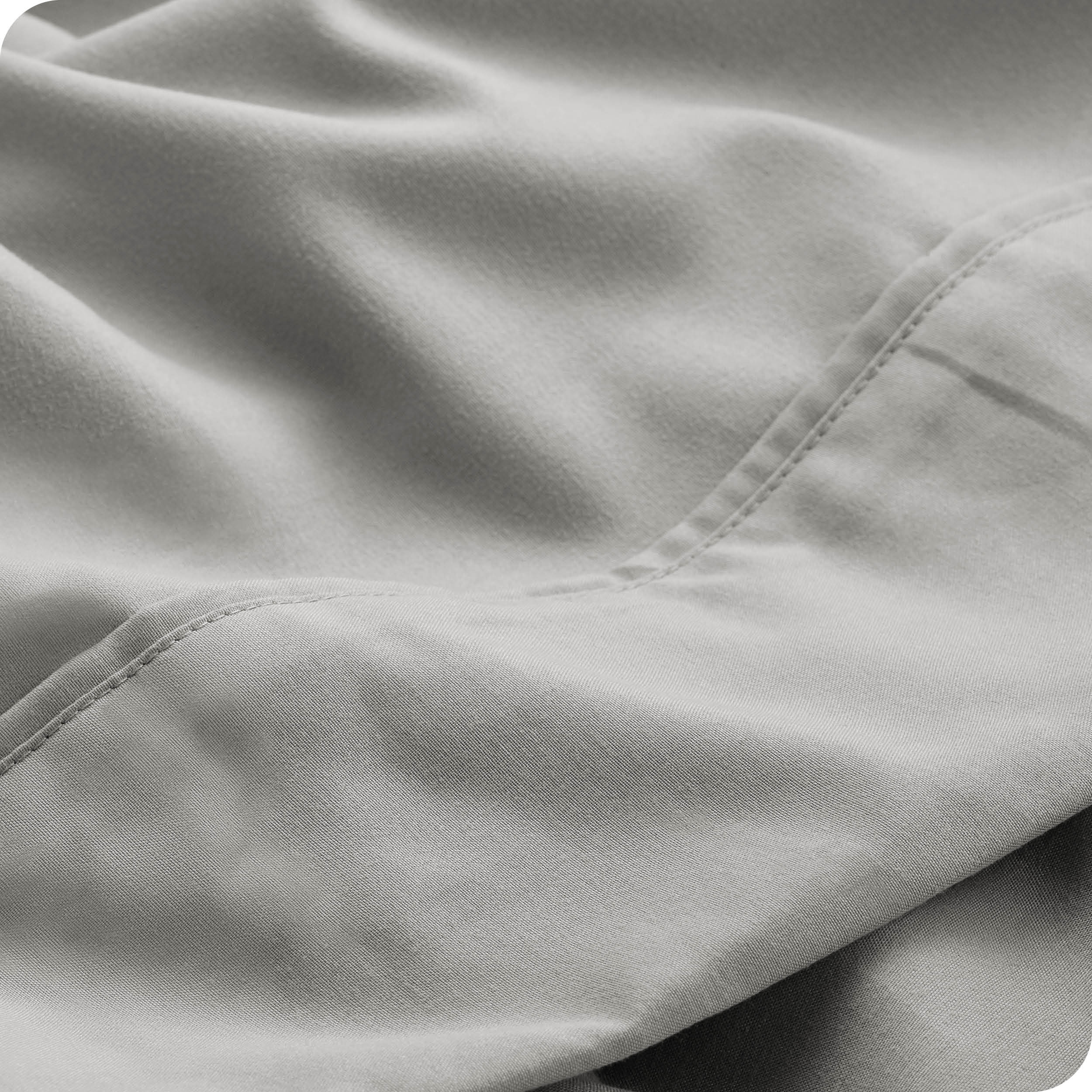 Close up of a white microfiber sheet showing the stitching and texture