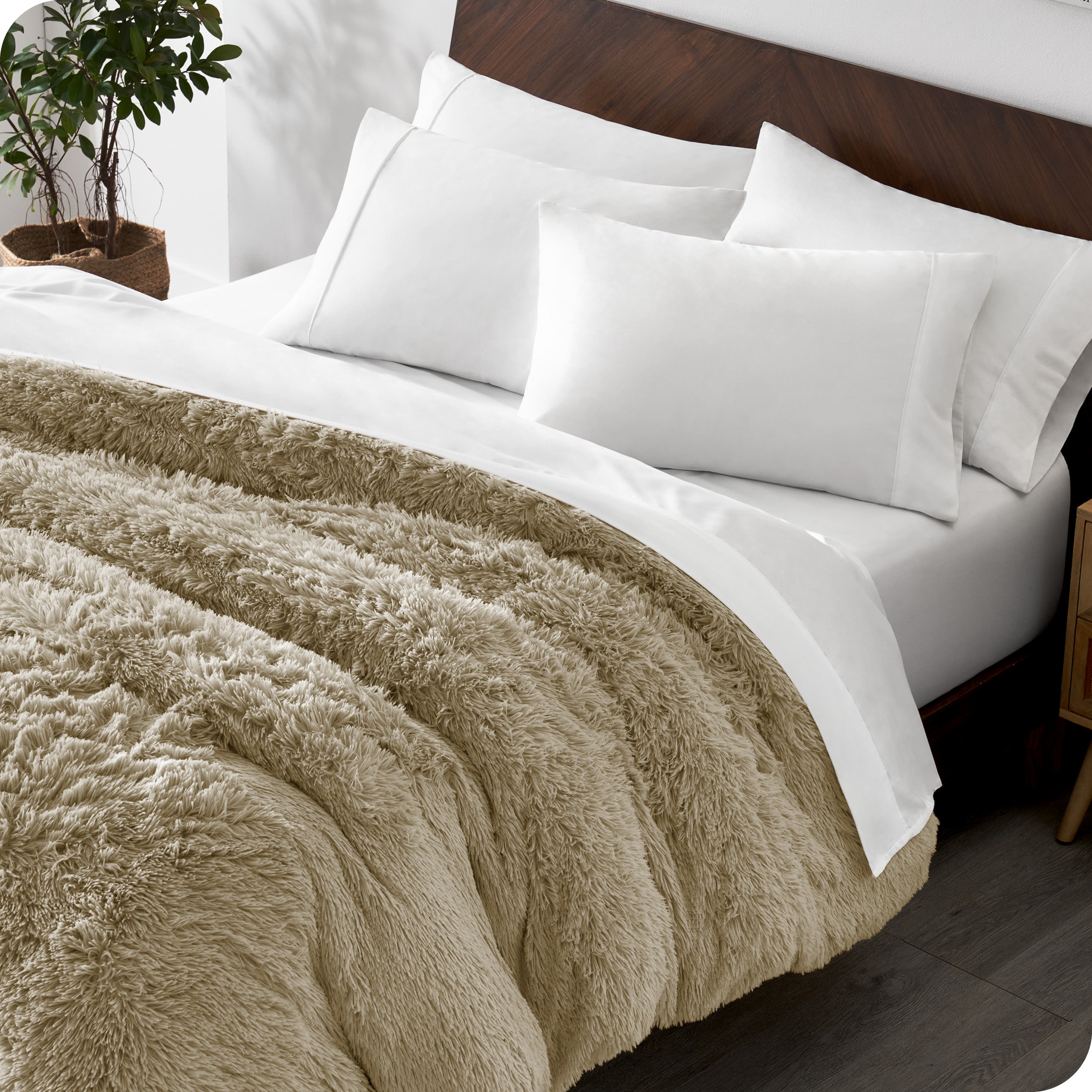 Diagonal view of a bed made with white sheets and pillowcases with a sand shaggy duvet cover on top