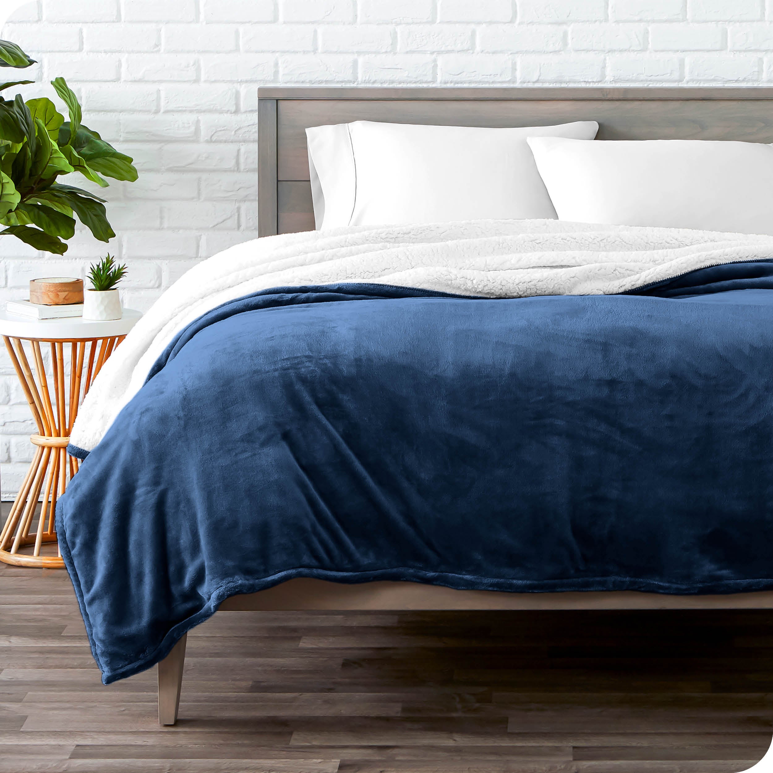 Blue Sherpa Blanket laying on a bed folded over itself part way