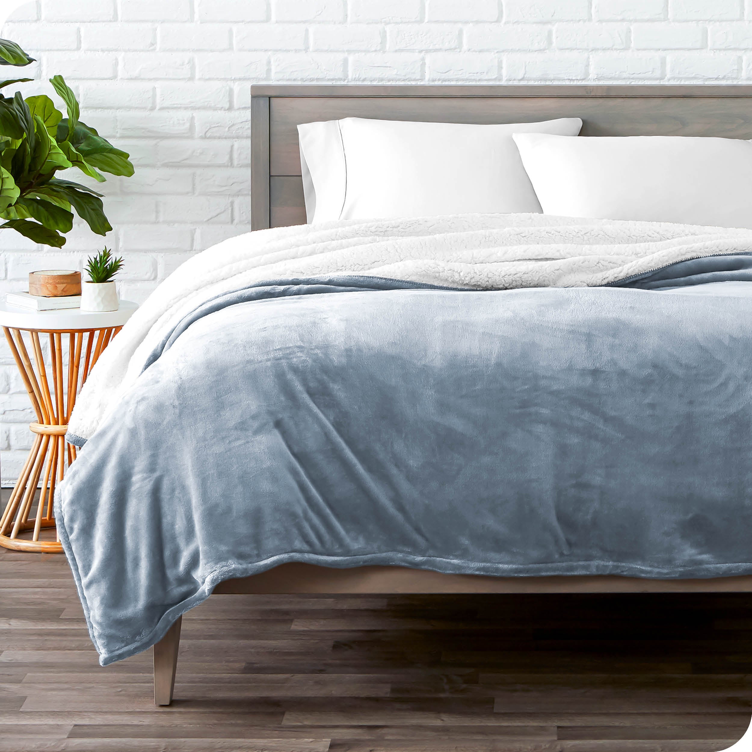 Blue Sherpa Blanket laying on a bed folded over itself part way