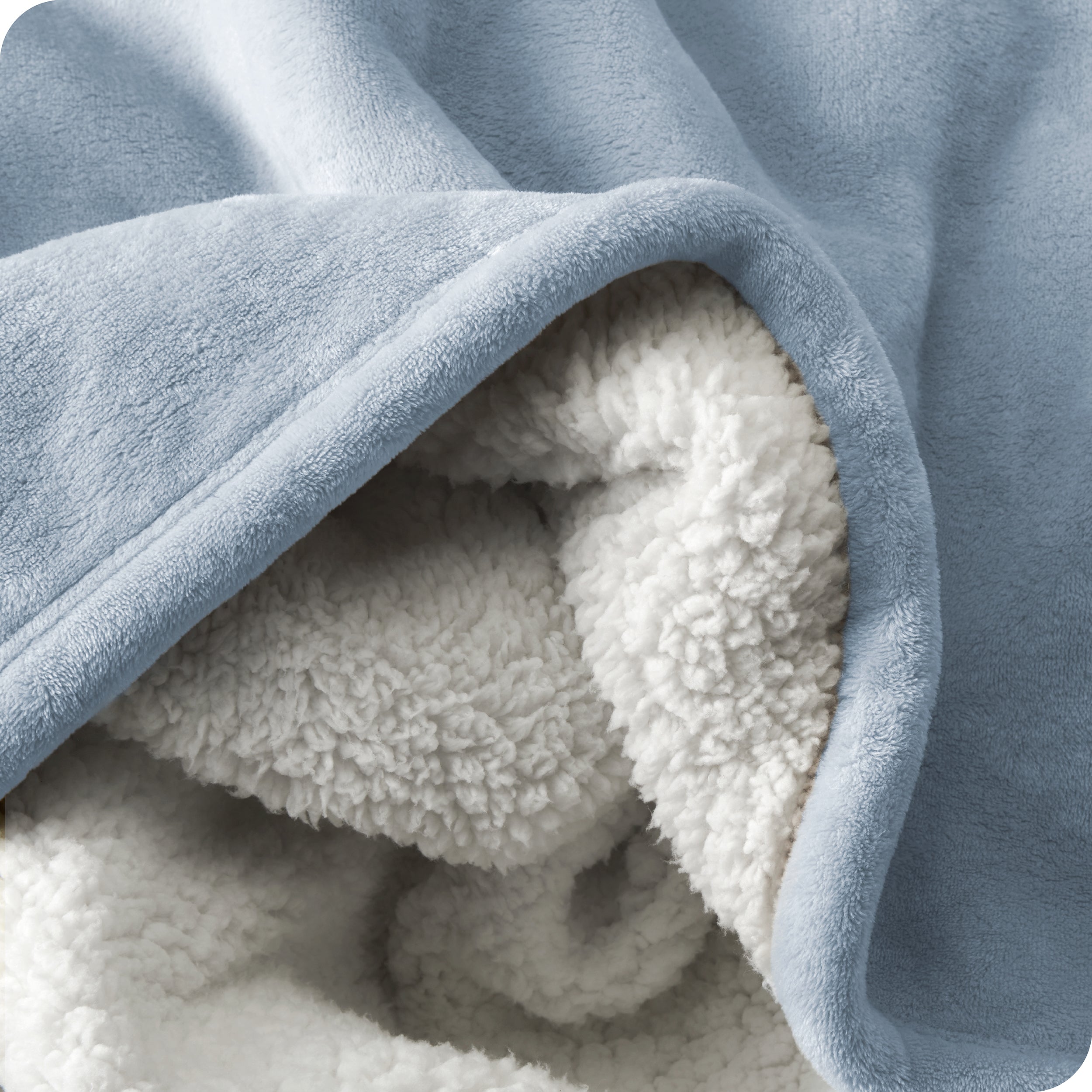 Close up of sherpa blanket showing texture of velvety soft side and sherpa backing