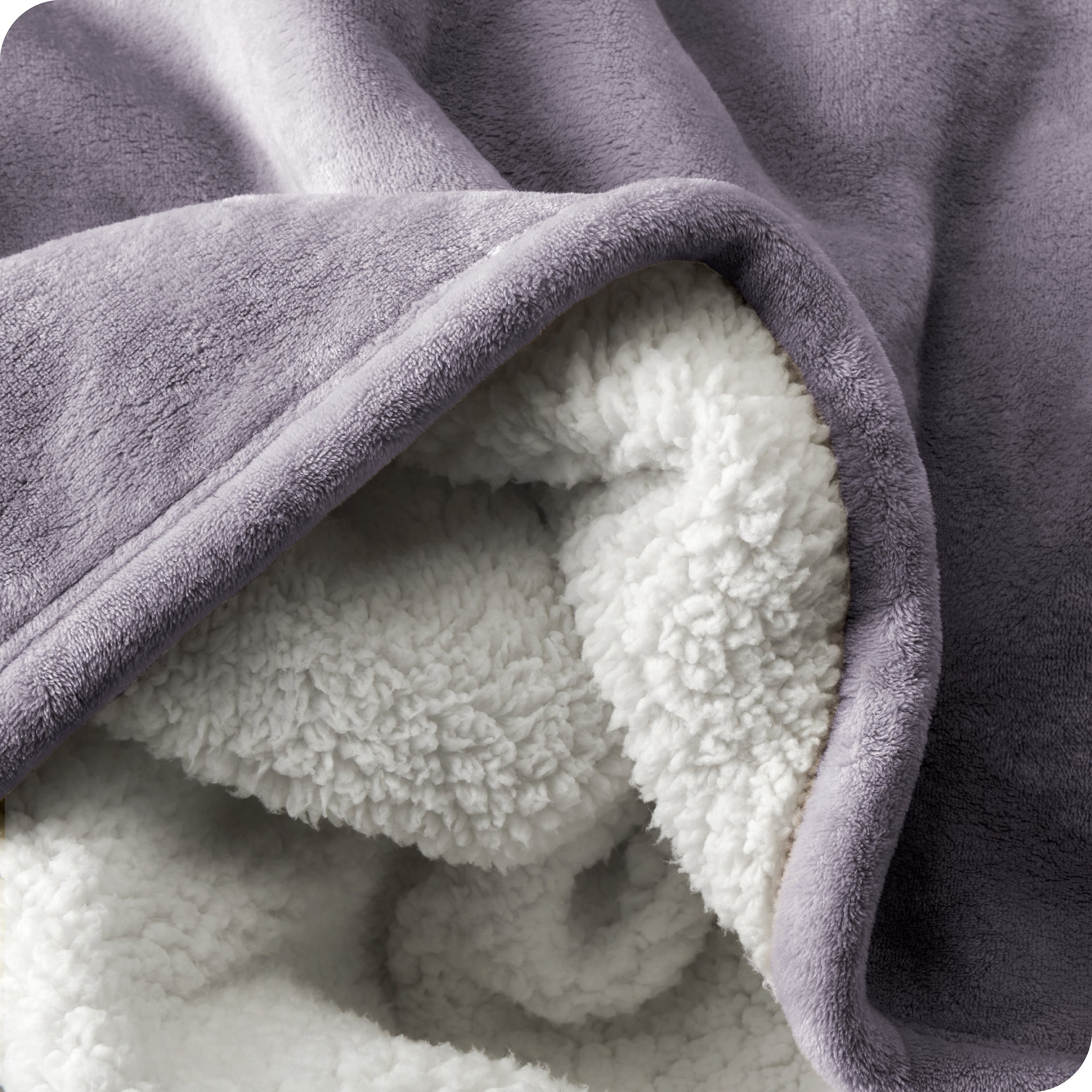 Close up of sherpa blanket showing texture of velvety soft side and sherpa backing