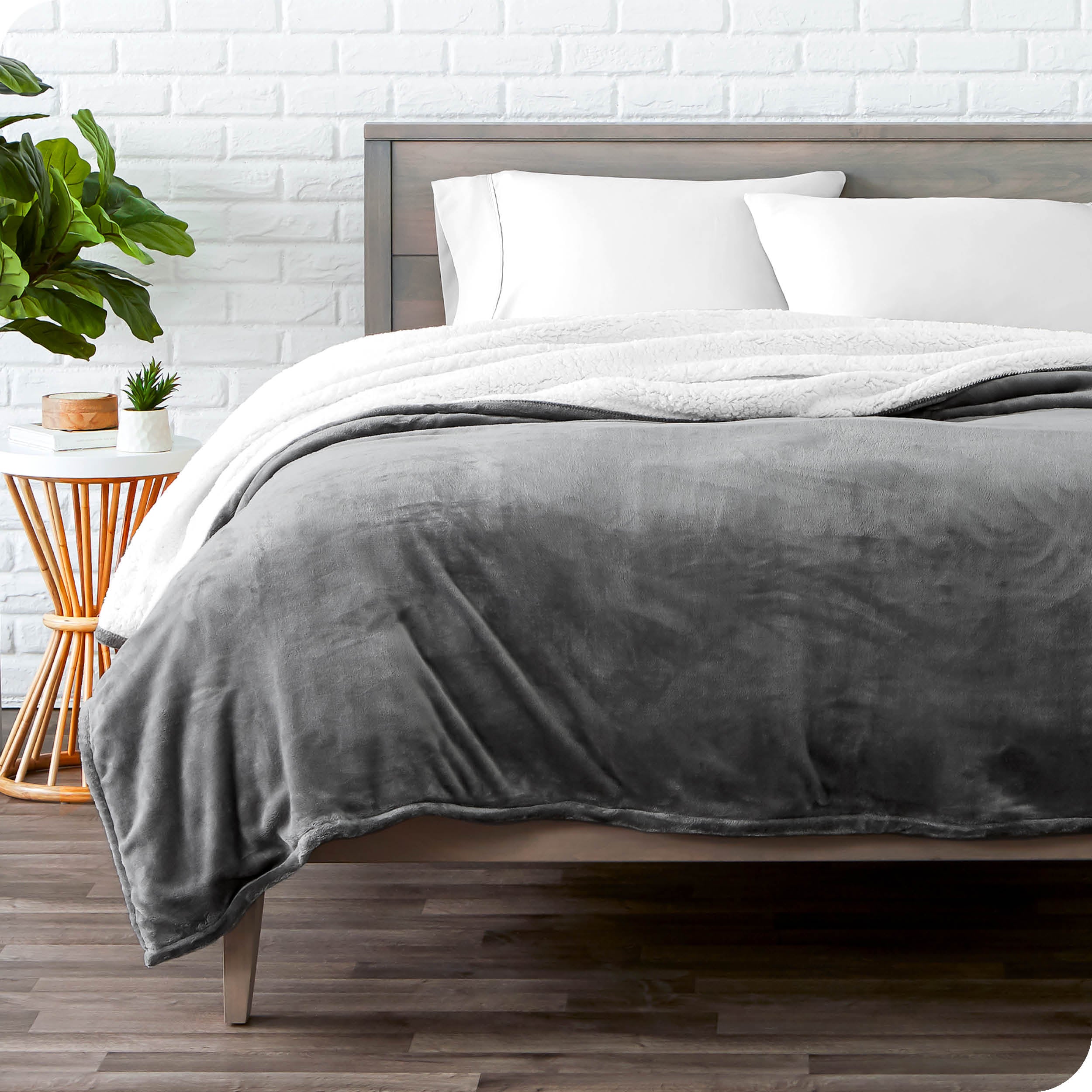 Grey Sherpa Blanket laying on a bed folded over itself part way