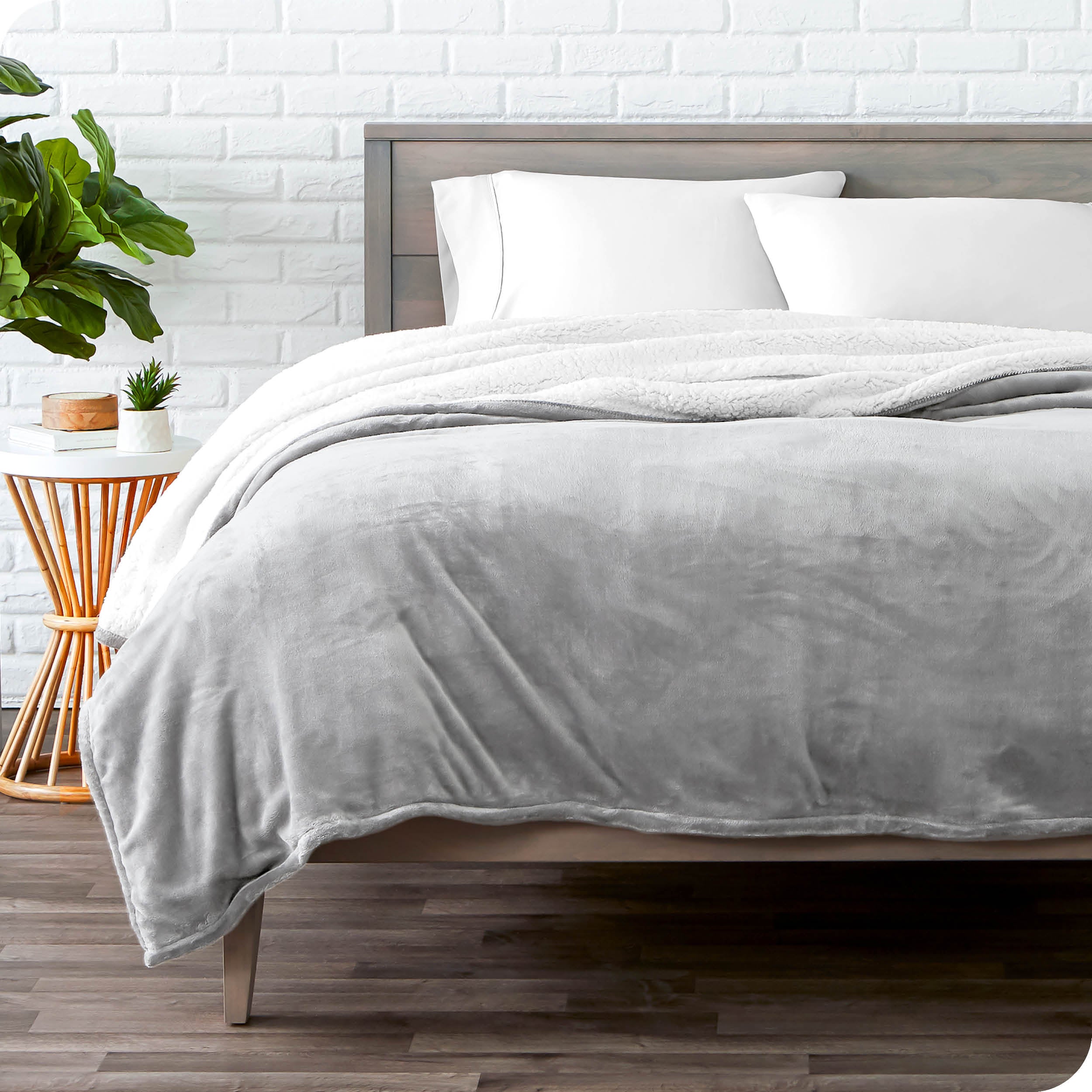 Light Grey Sherpa Blanket laying on a bed folded over itself part way