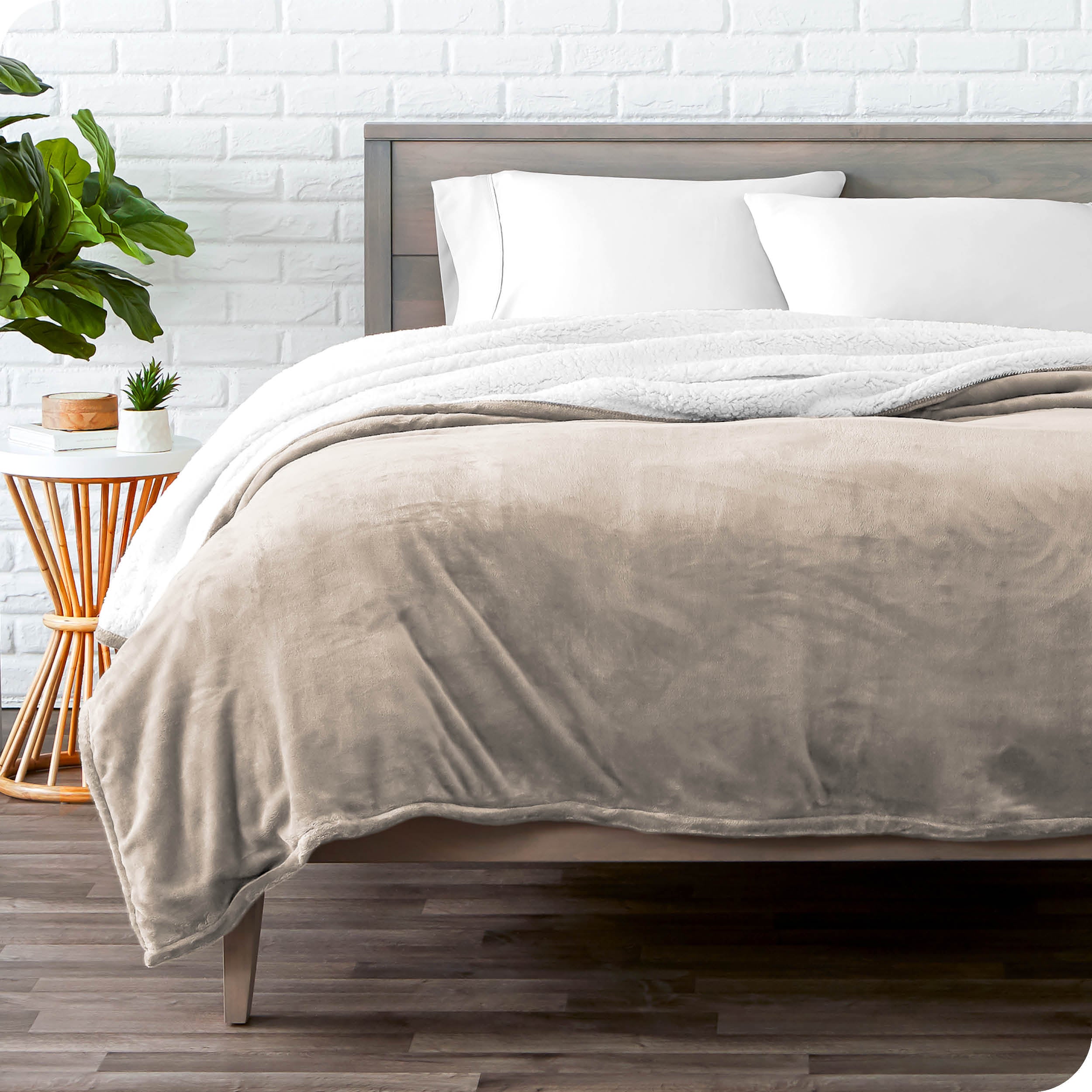 Taupe Sherpa Blanket laying on a bed folded over itself part way