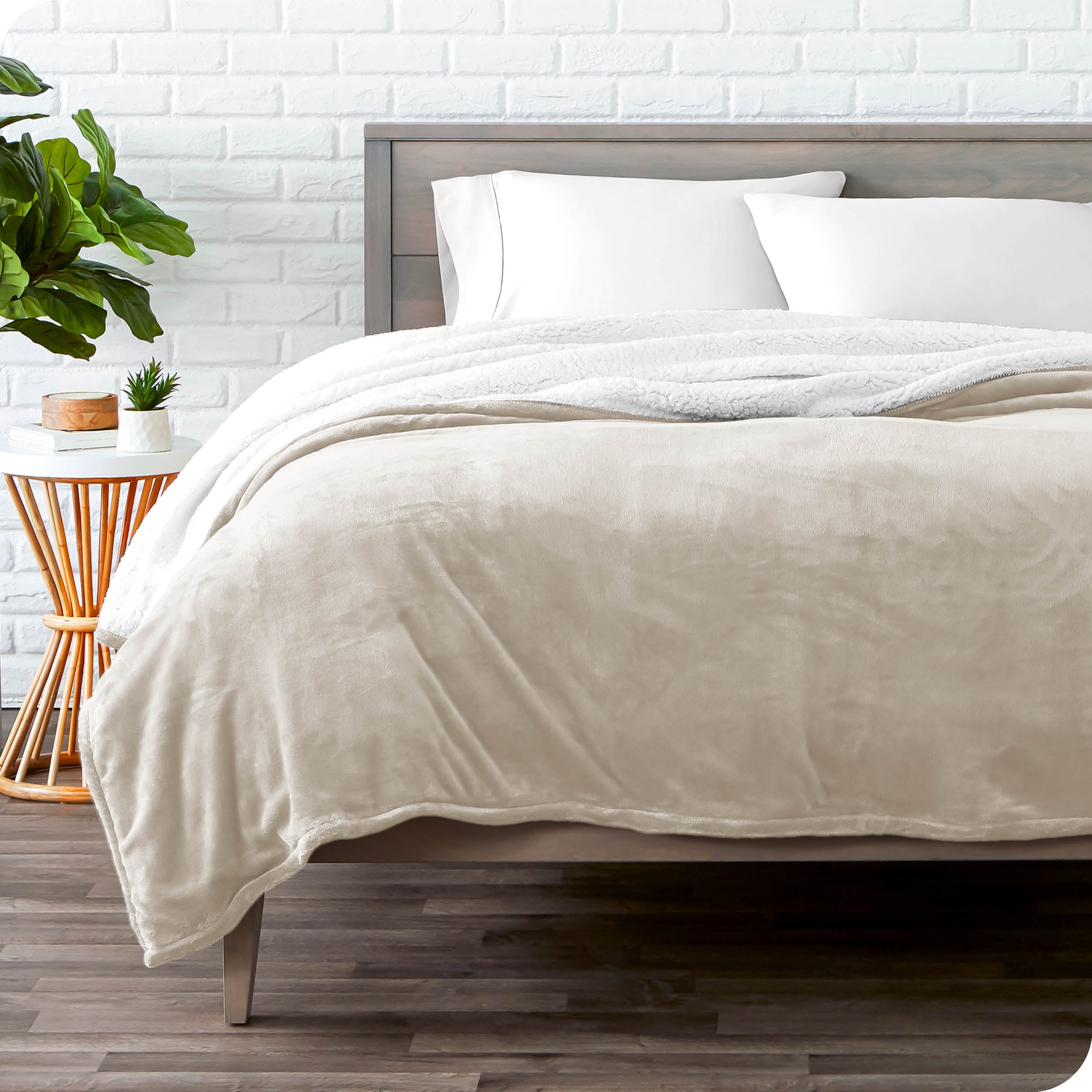 Oyster Sherpa Blanket laying on a bed folded over itself part way