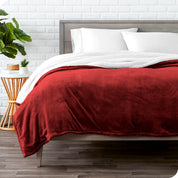 Red Sherpa Blanket laying on a bed folded over itself part way