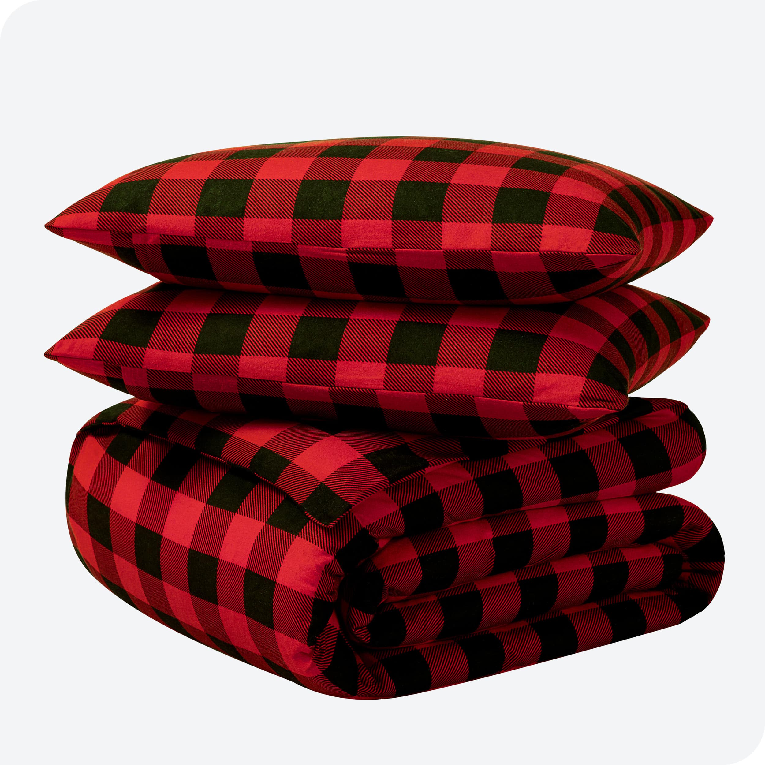 A folded stack of a printed flannel duvet cover with two pillows on top.