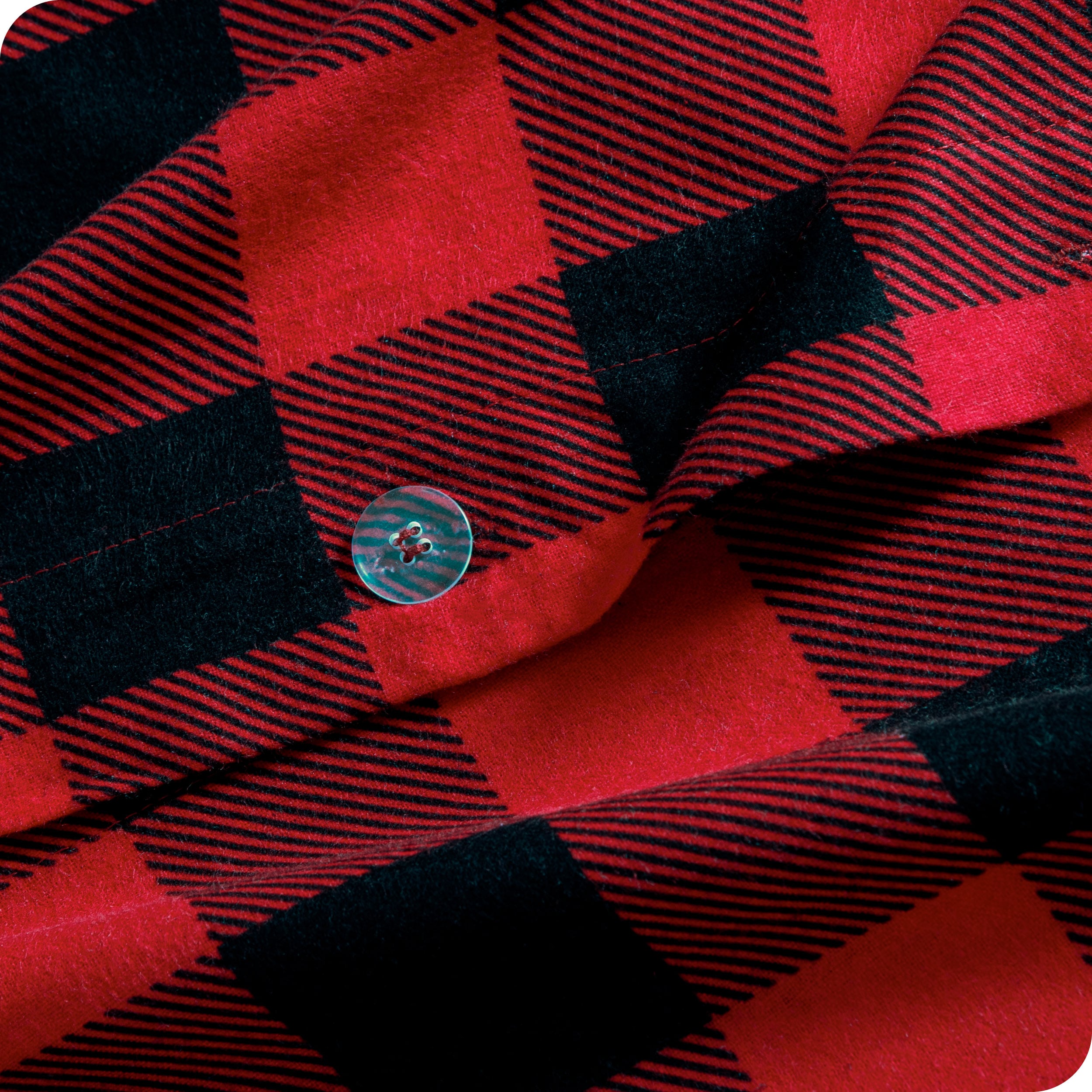 A close up of the flannel duvet cover showing the button, lining, texture, and pattern.