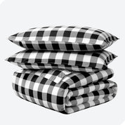 A folded stack of a printed flannel duvet cover with two pillows on top.