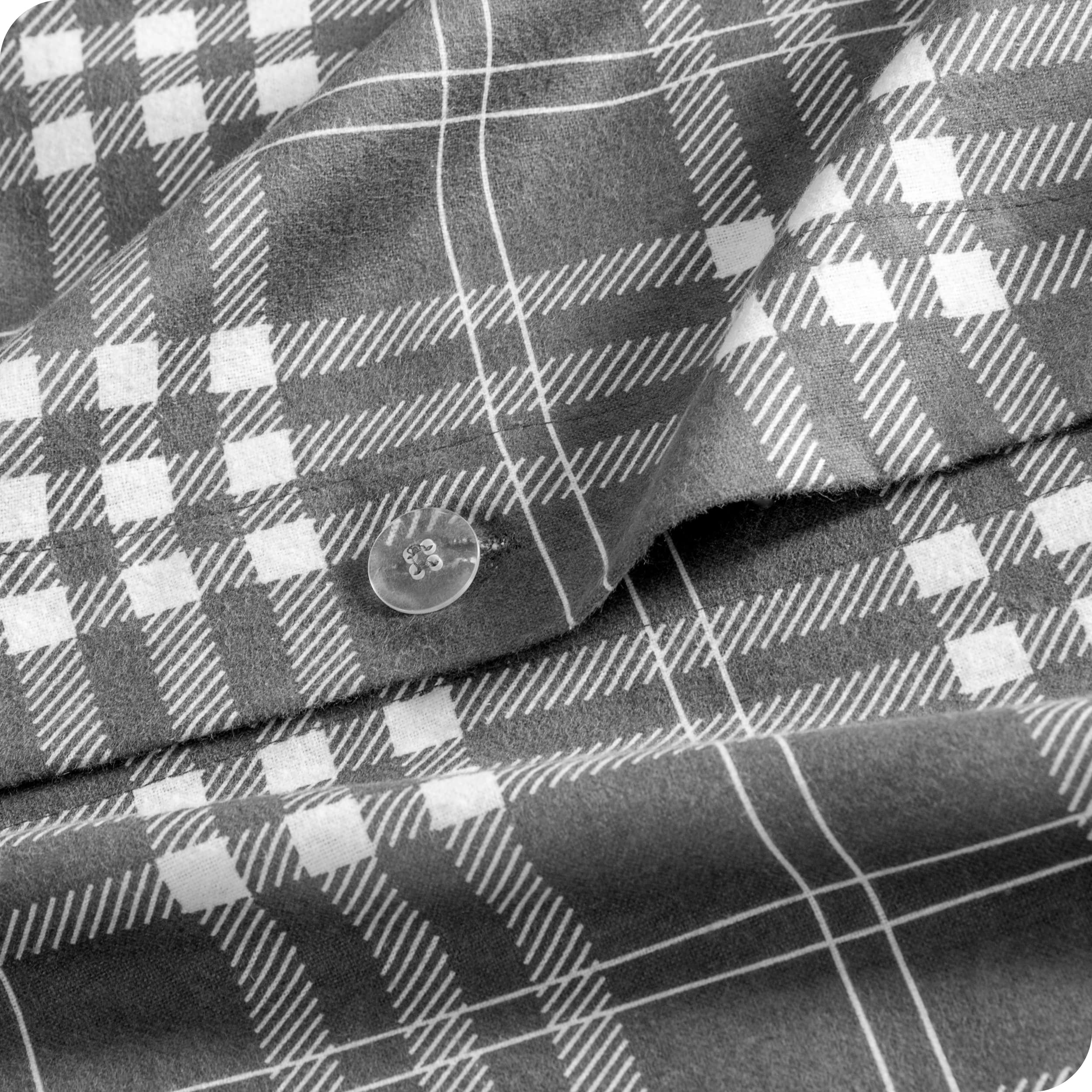 A close up of the flannel duvet cover showing the button, lining, texture, and pattern.