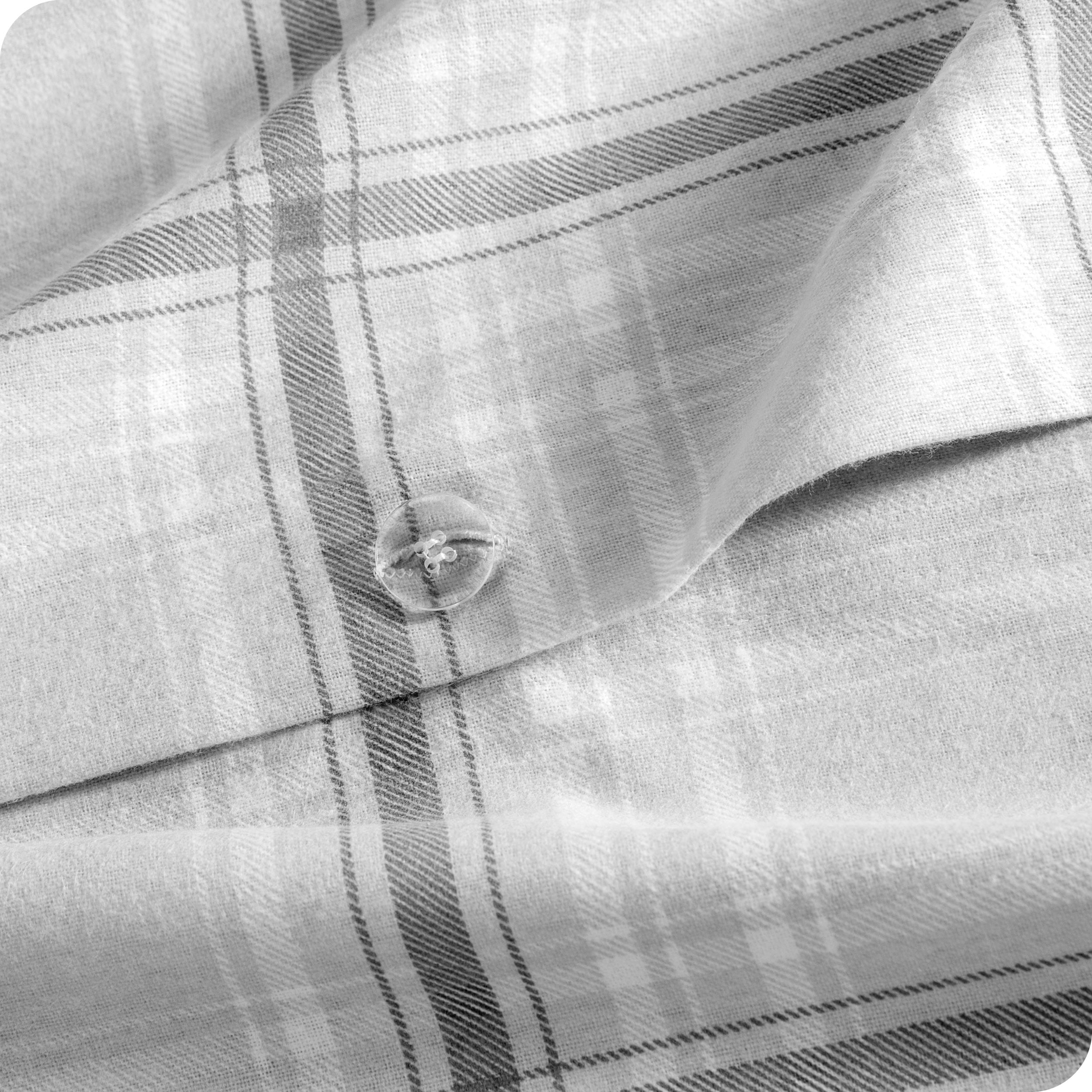 A close up of the flannel duvet cover showing the button, lining, texture, and pattern.