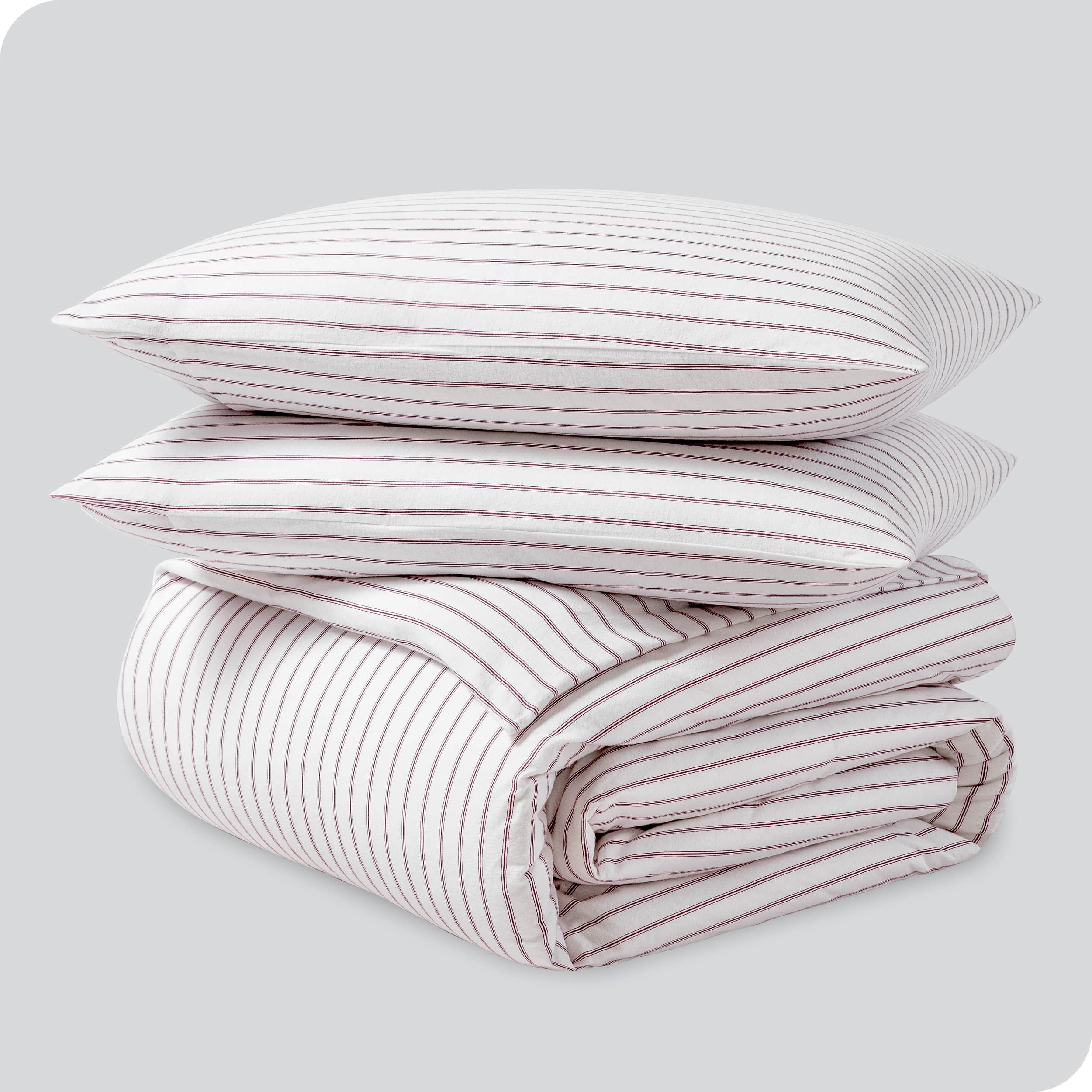 A folded stack of a printed flannel duvet cover with two pillows on top.